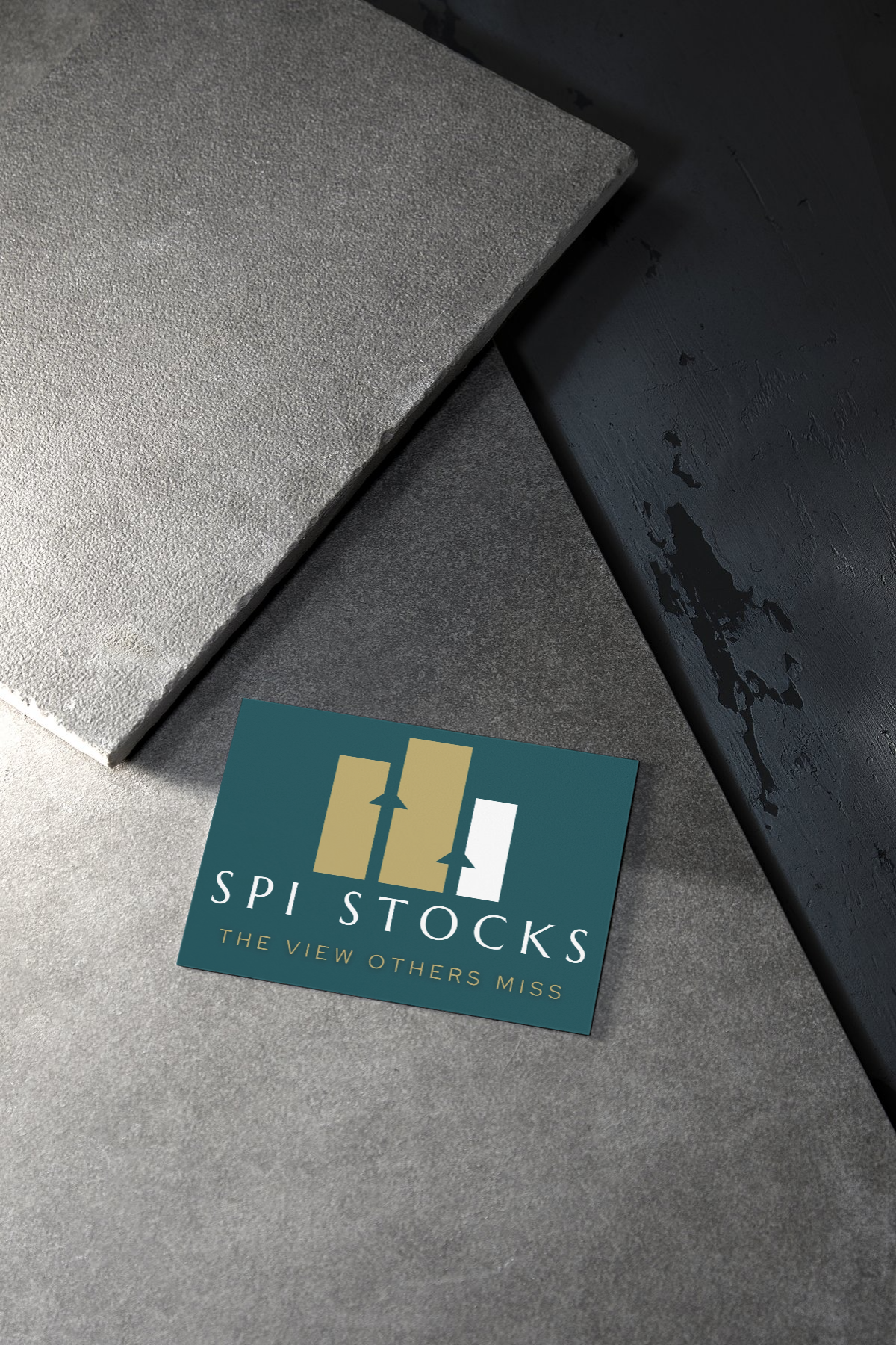 A business card from SPI Stocks, with the tagline 'The View Others Miss,' placed on a gray textured surface next to black and gray textured blocks.