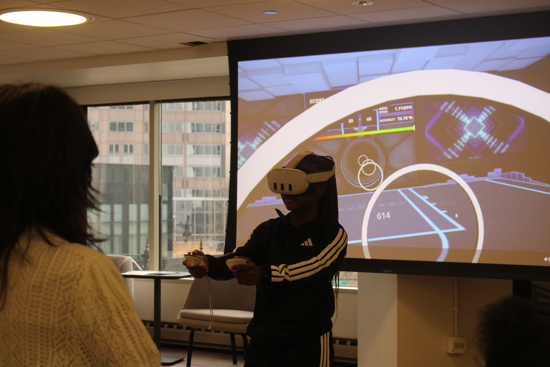 Person in VR headset playing immersive game in an office.