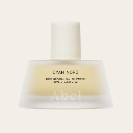 A bottle of Abel Cyan Nori perfume with a white cap, label indicating it's a 100% natural eau de parfum, 50ml, with a frosted glass finish.