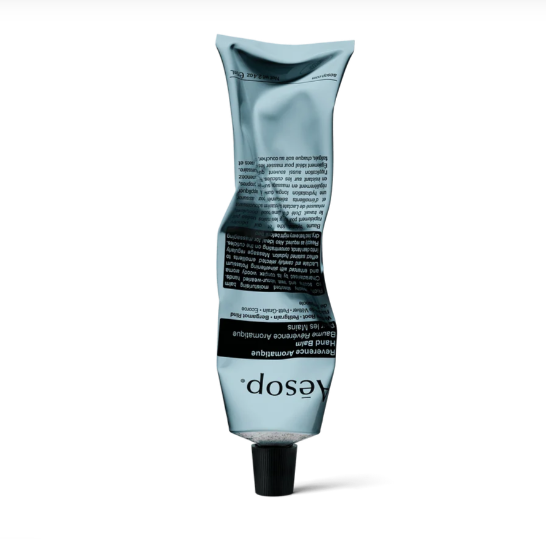 Crushed tube of Eos hand cream with black cap, standing upright