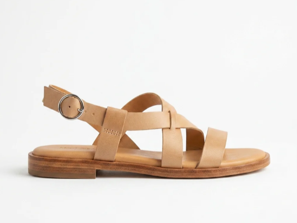 Tan leather sandal with a buckle strap on a white background