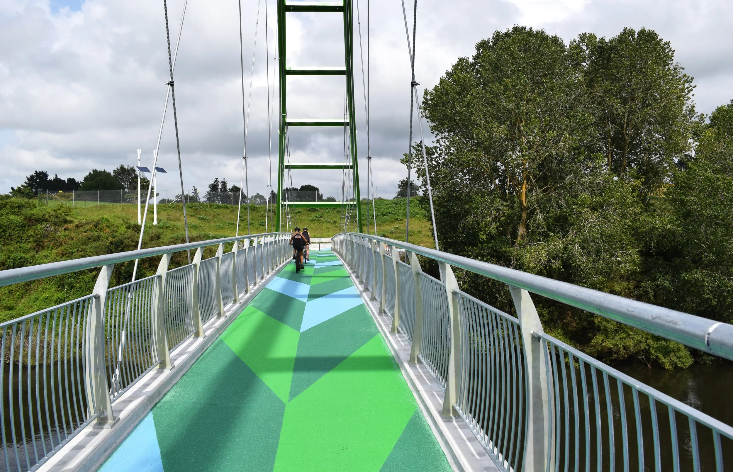 Locals biking over Te Awa River Ride Bridge