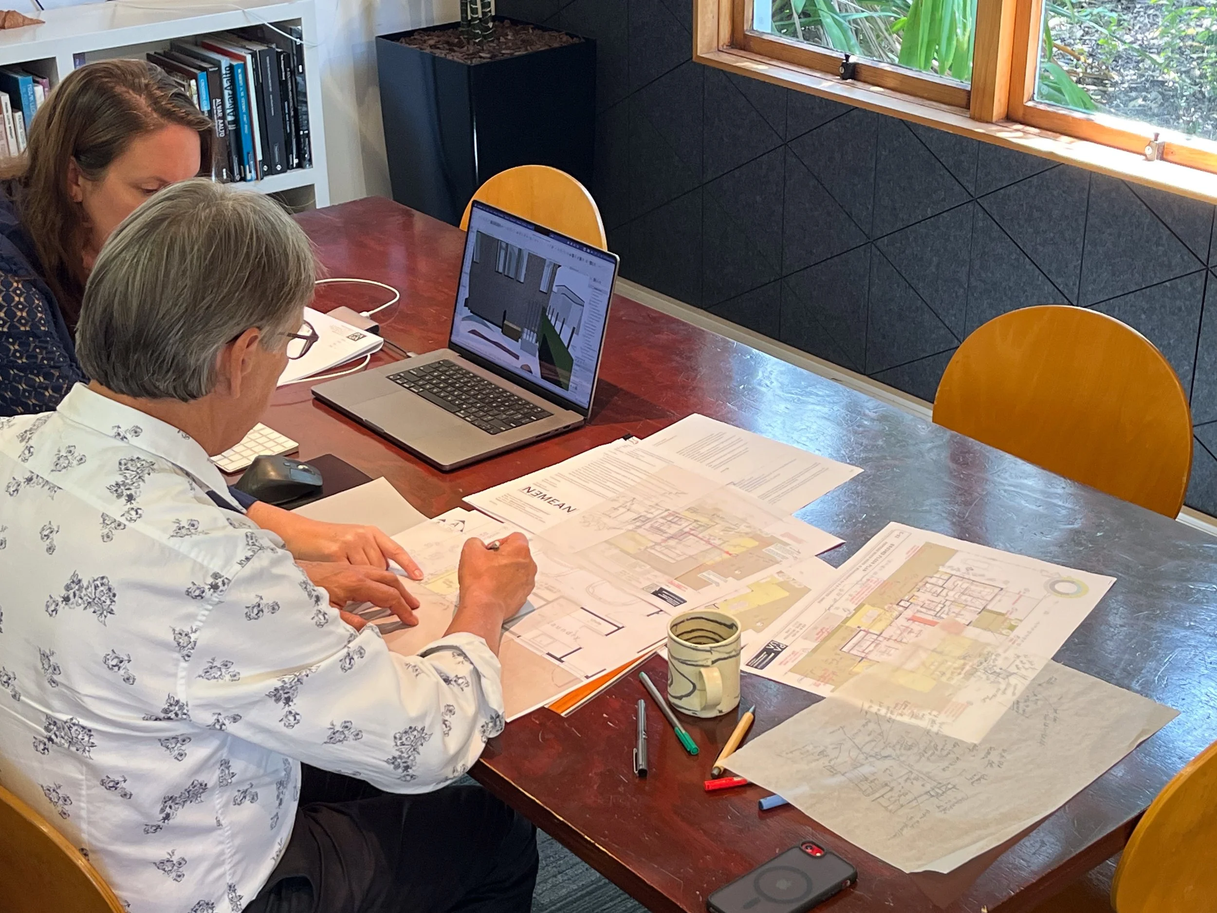 Architect Antanas working on project plans in collaboration with client