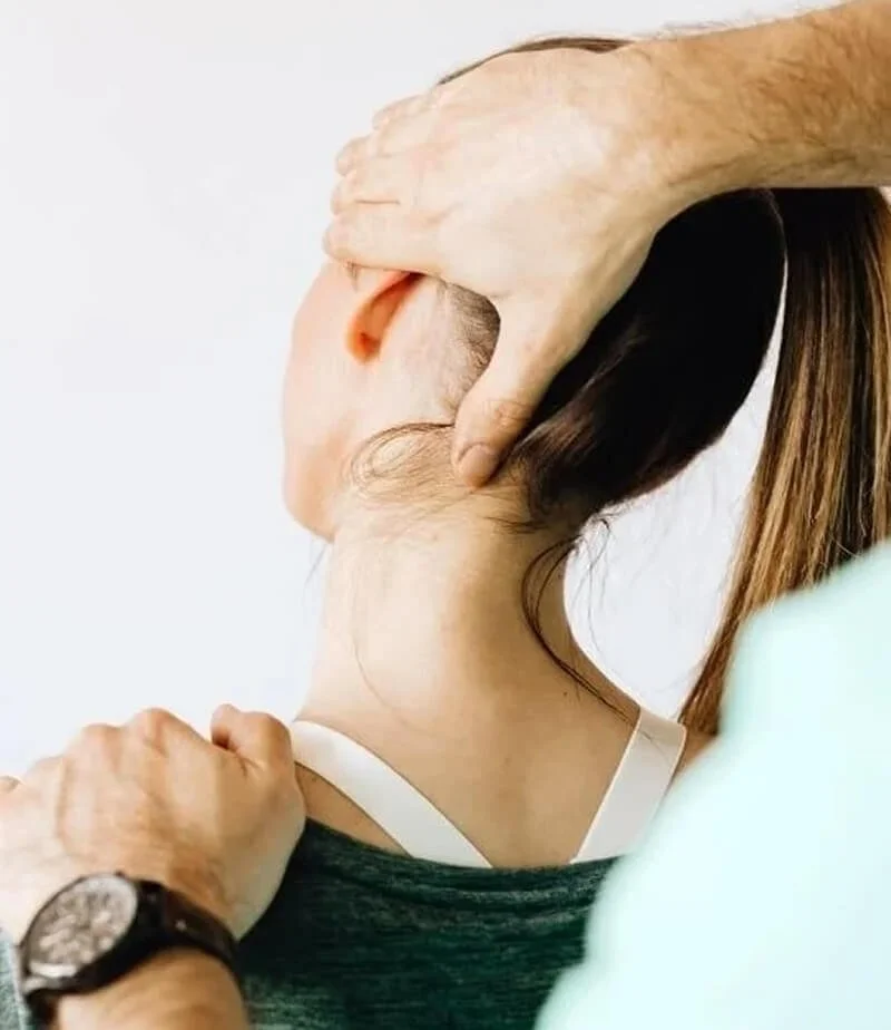 A person receiving a chiropractic neck adjustment from a healthcare professional.