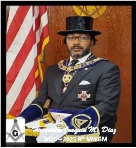 A man in formal Masonic attire, wearing a top hat and medallions, sitting in front of an American flag and a Masonic symbol. The text over the image reads 'Joaquin M. Diaz, 2020-2025th MWGM'.