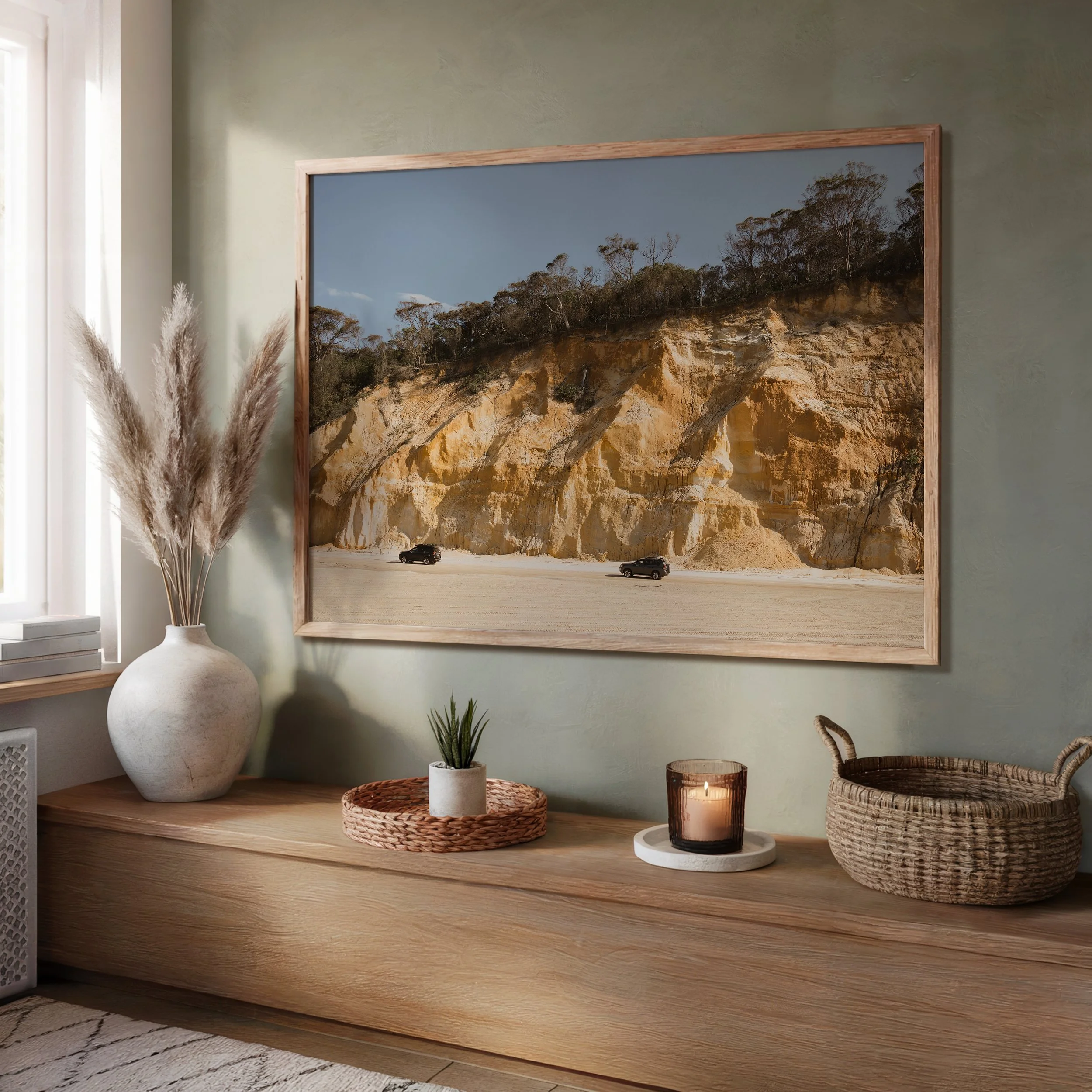 Framed sand‑cliff and 4WD landscape photograph displayed in a living room setting