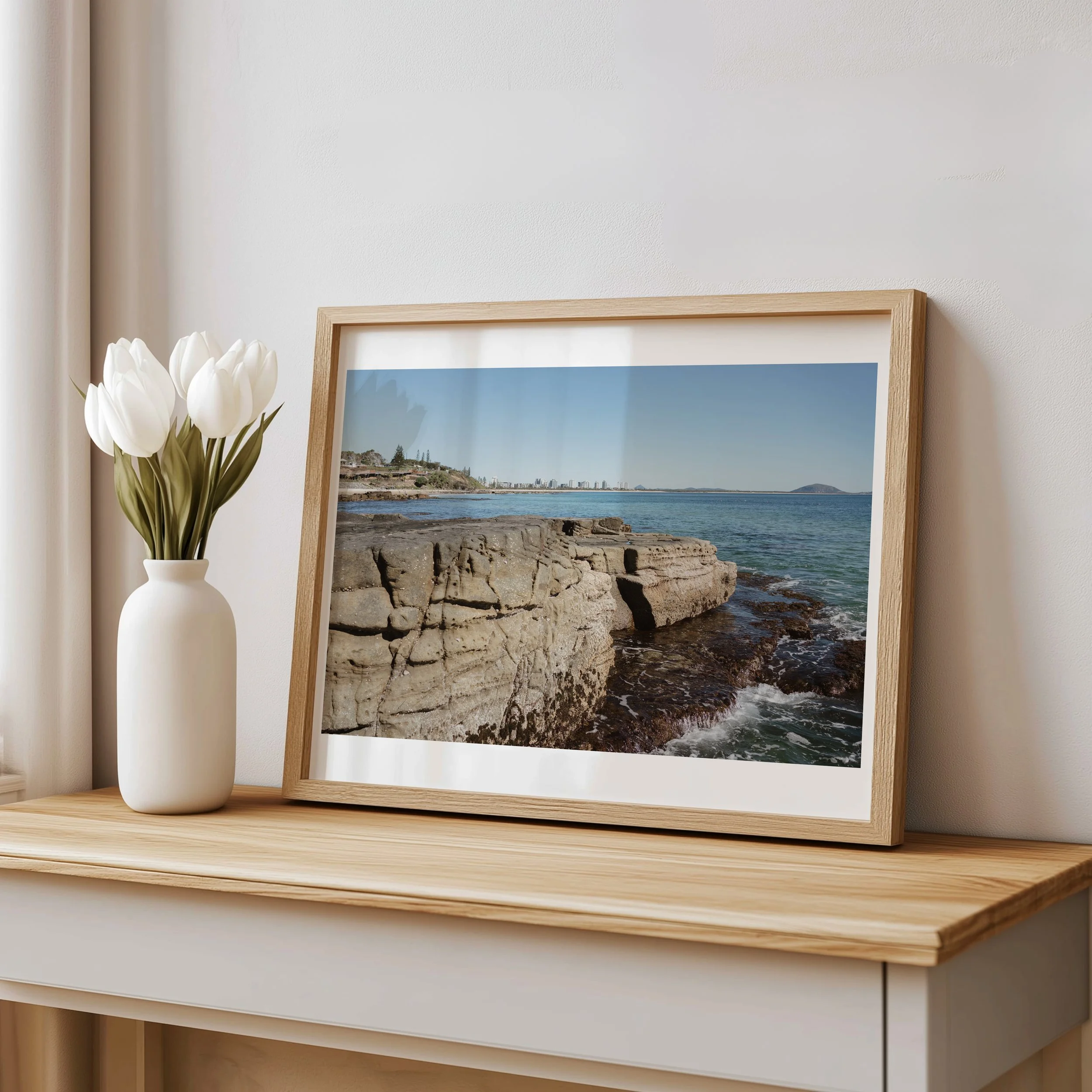 Coastal rock‑pool landscape print styled on a console table