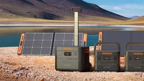 A portable solar power station with two solar panels connected, set up outdoors near a body of water with mountains in the background.