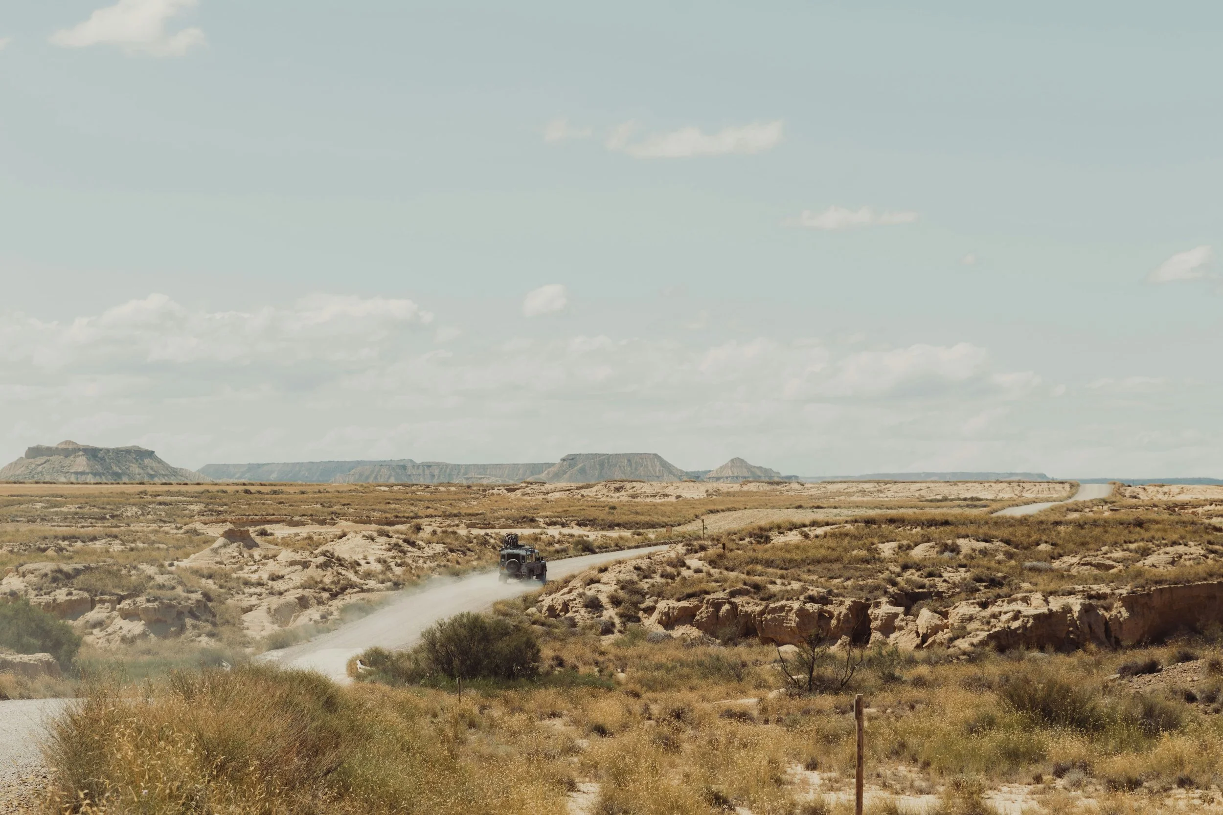 Road going through the red rocks and desert with a blue sky