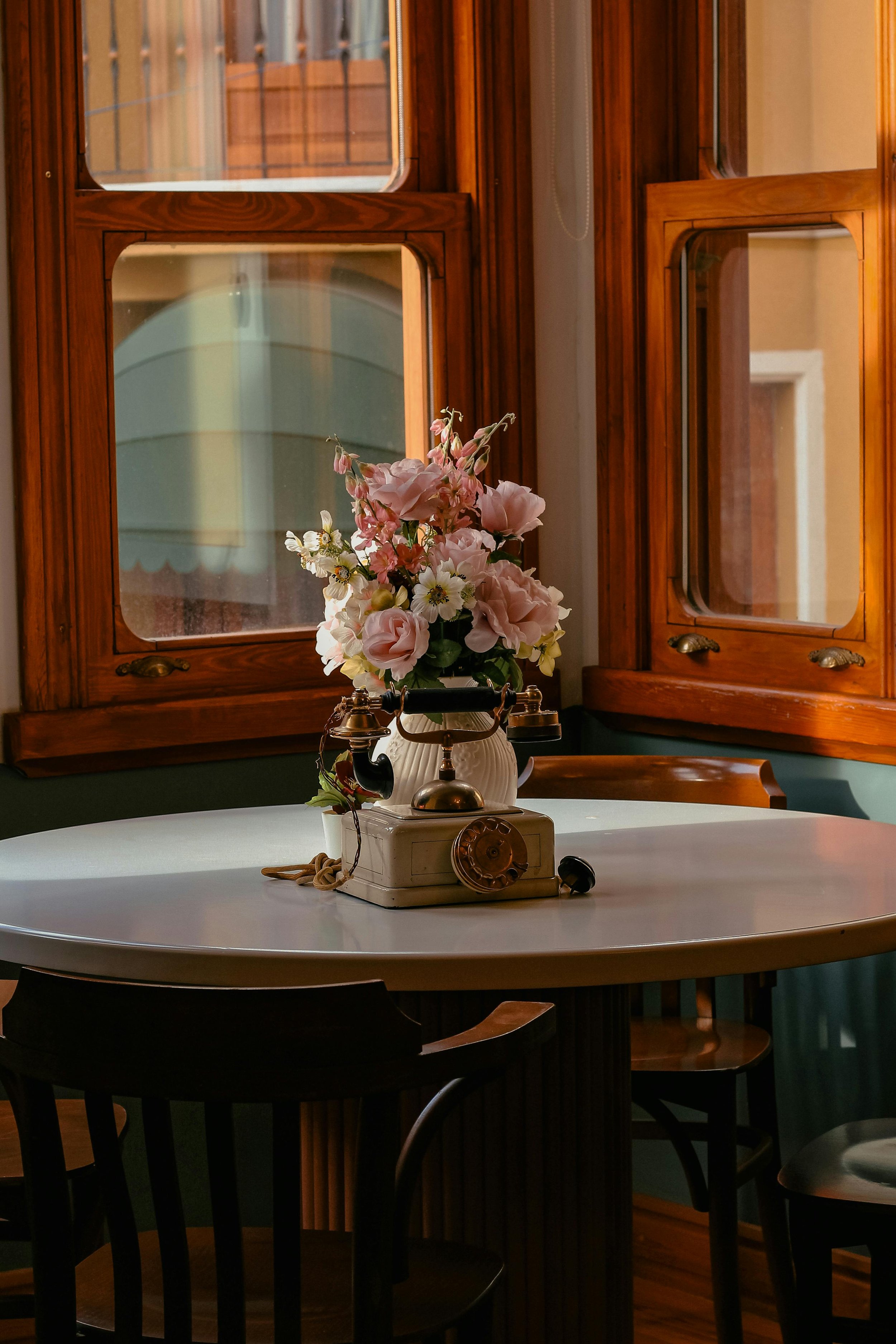 Vase of flowers and vintage telephone in the middle of a kitchen table