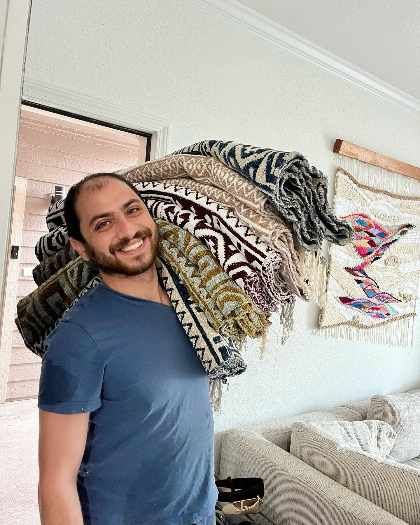 Mahmoud holding family rugs.jpg