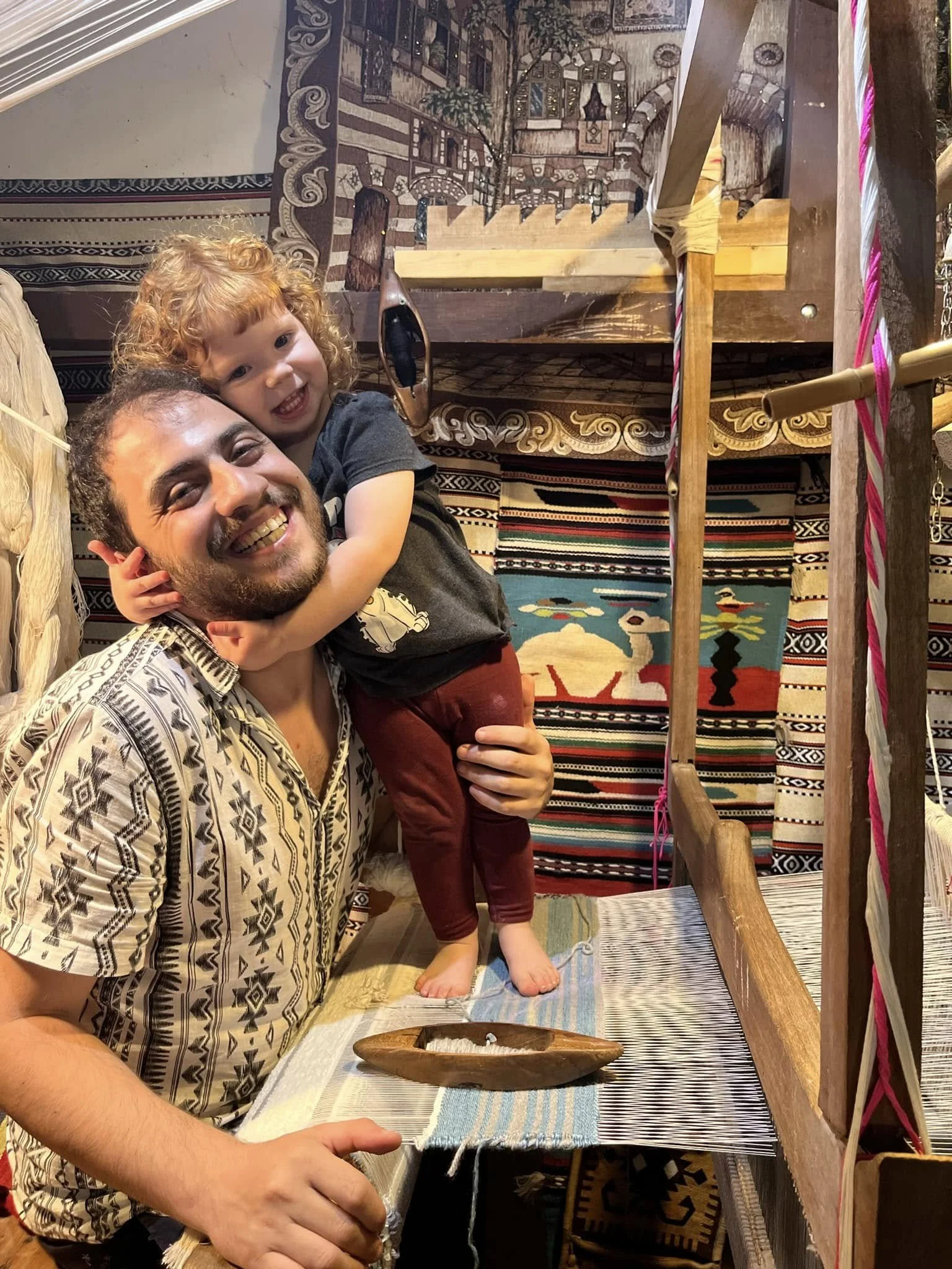 Mila on loom w dad.jpg