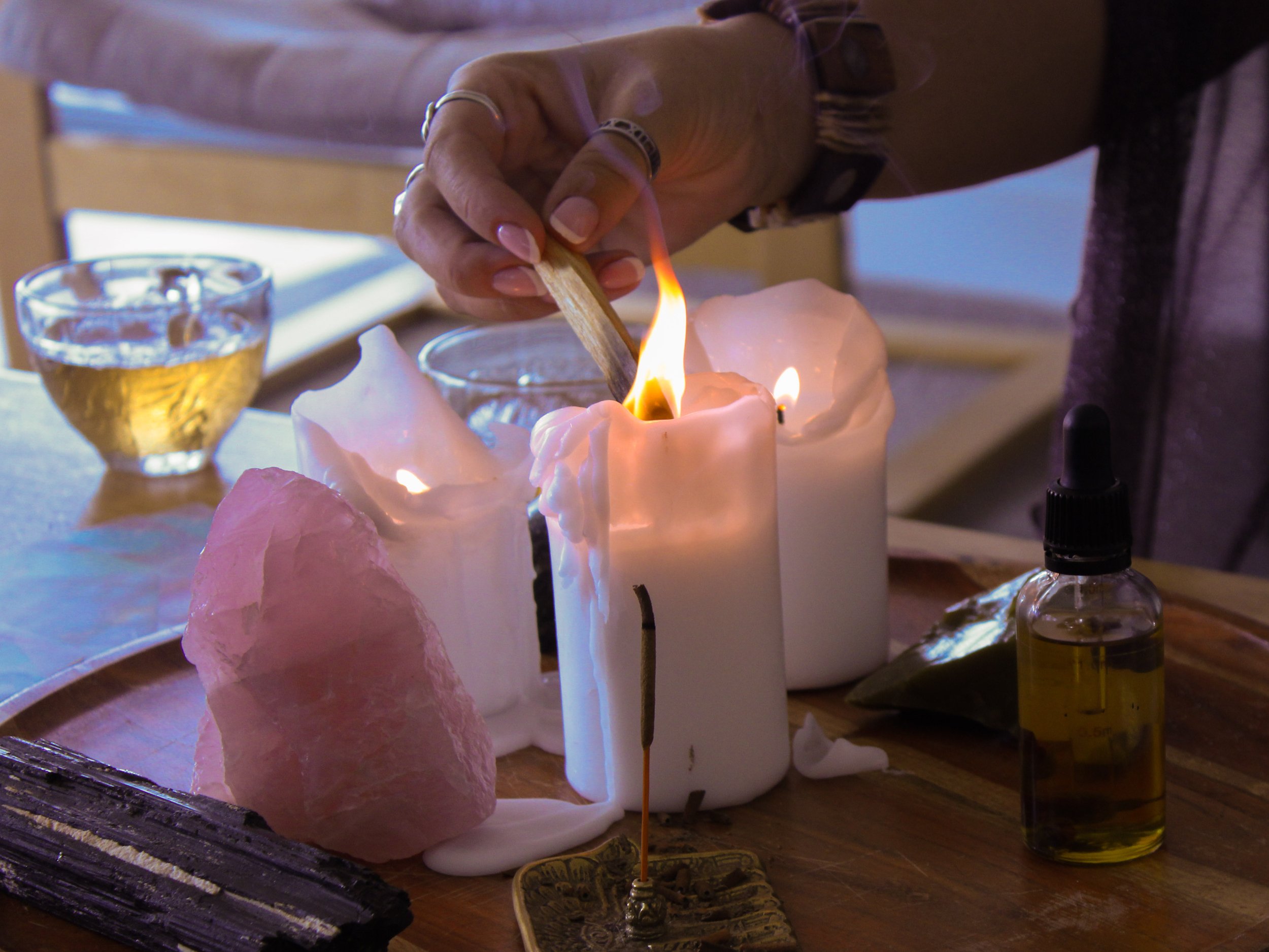 lighting candles and burning palo santo while drinking rose tea during a wellness retreat