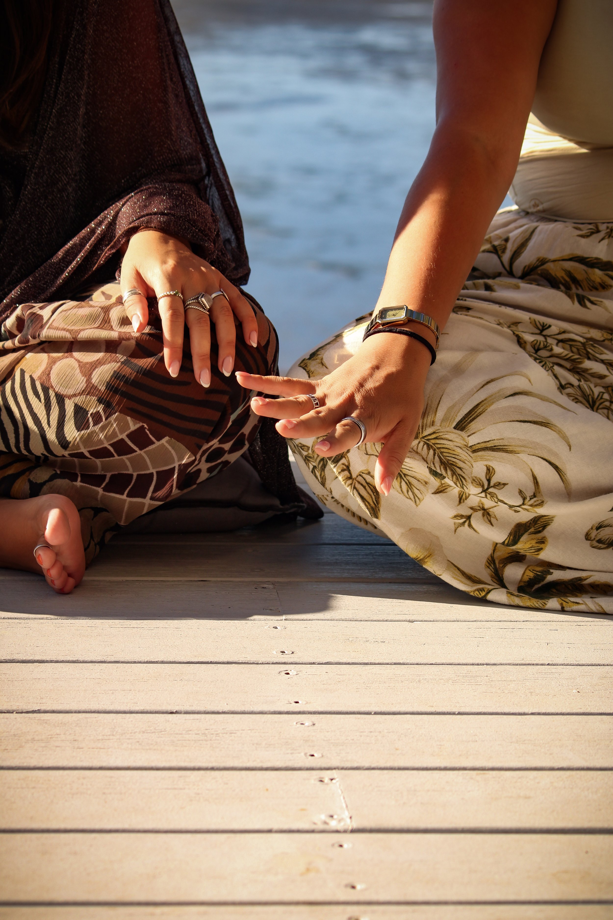 female business owners and friends sharing a supportive touch while hosting a wellness retreat by the beach