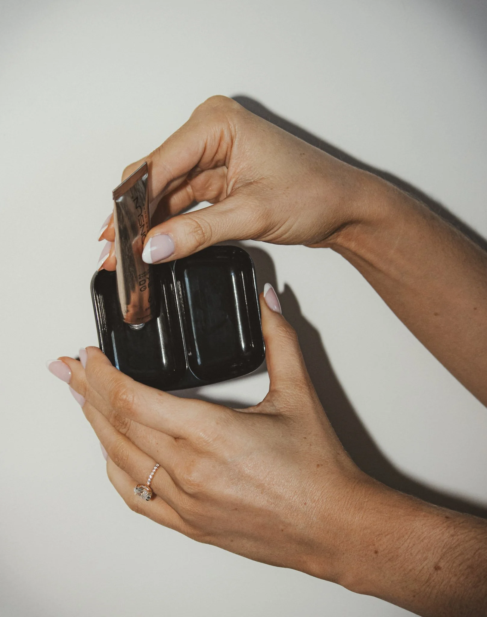 detail shot of hands mixing brow tint for beauty branding photoshoot