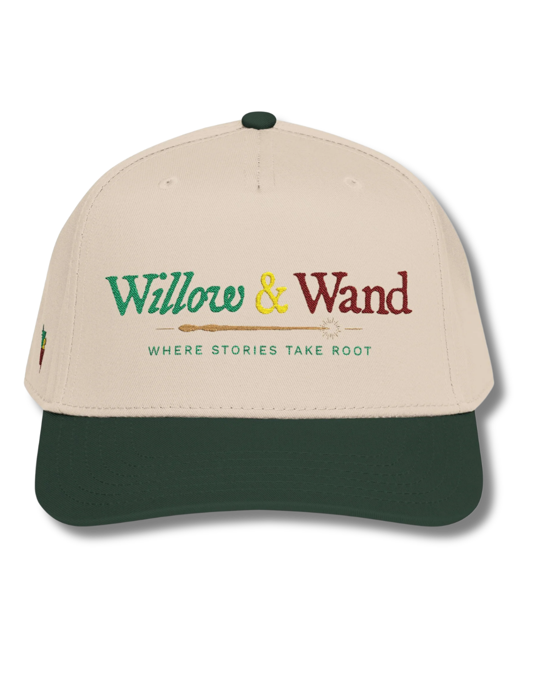 A beige and green baseball cap with embroidered text that reads 'Willow & Wand' and the slogan 'Where Stories Take Root' underneath.