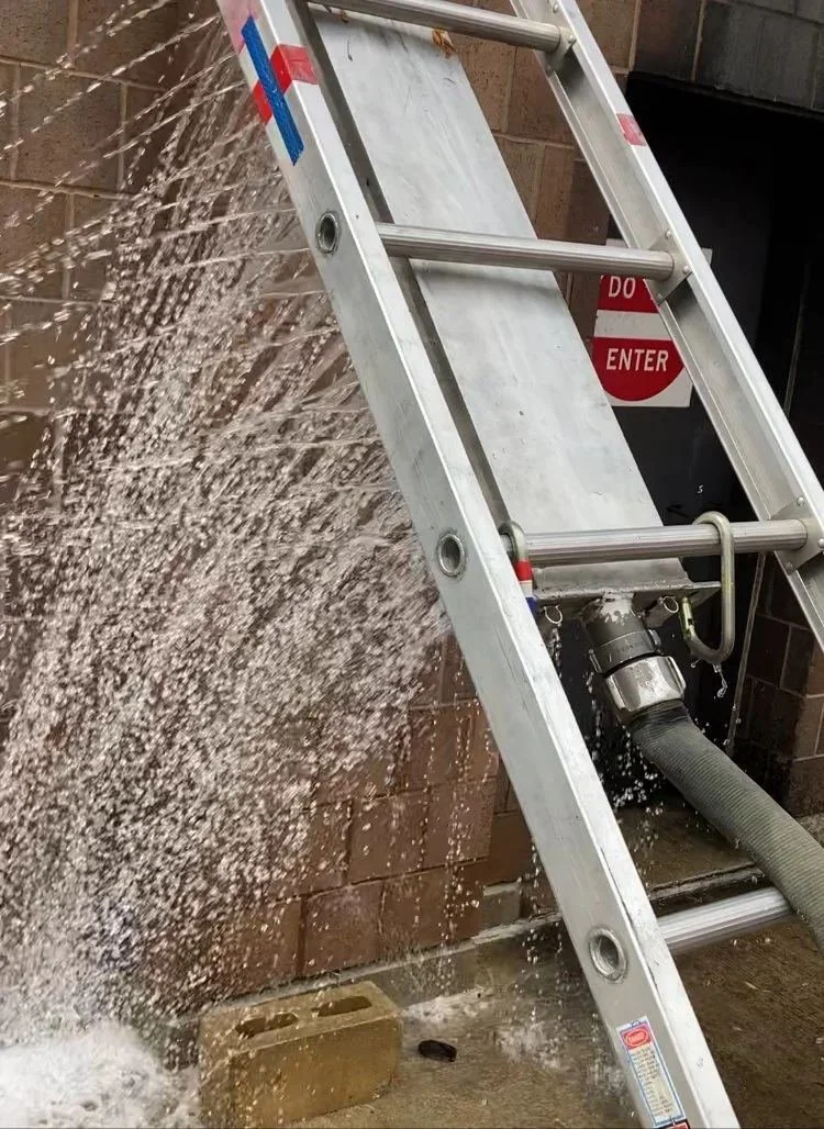 Poseidon clipped under a ground ladder as a gross decontamination shower