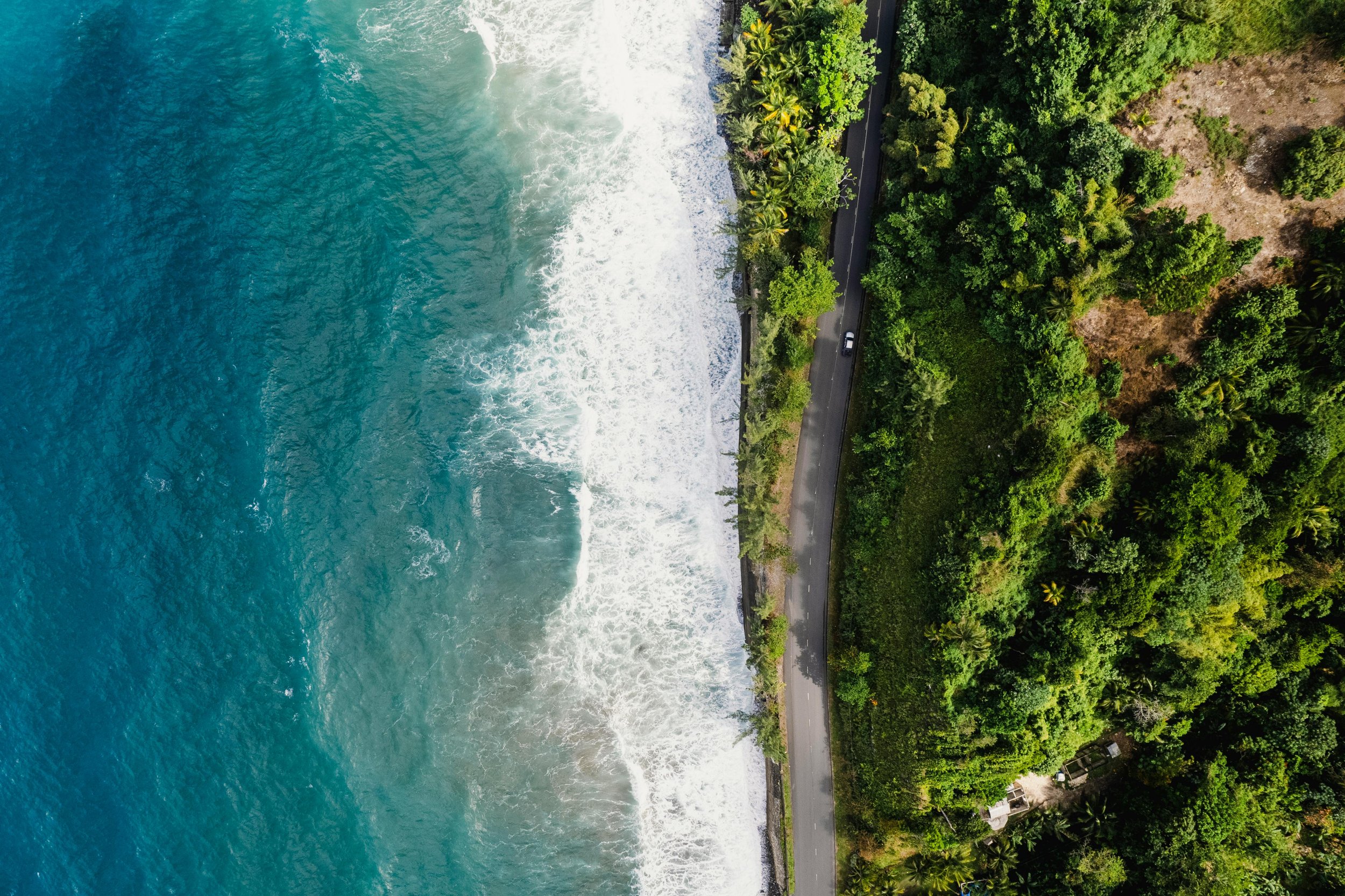 Aerial view of waves meeting a sandy shoreline.