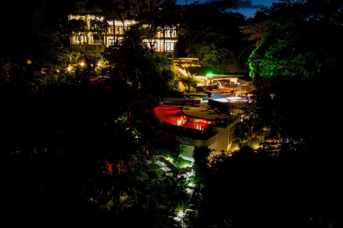 Evening aerial view of Geejam hotel with warm lights and tropical surroundings.