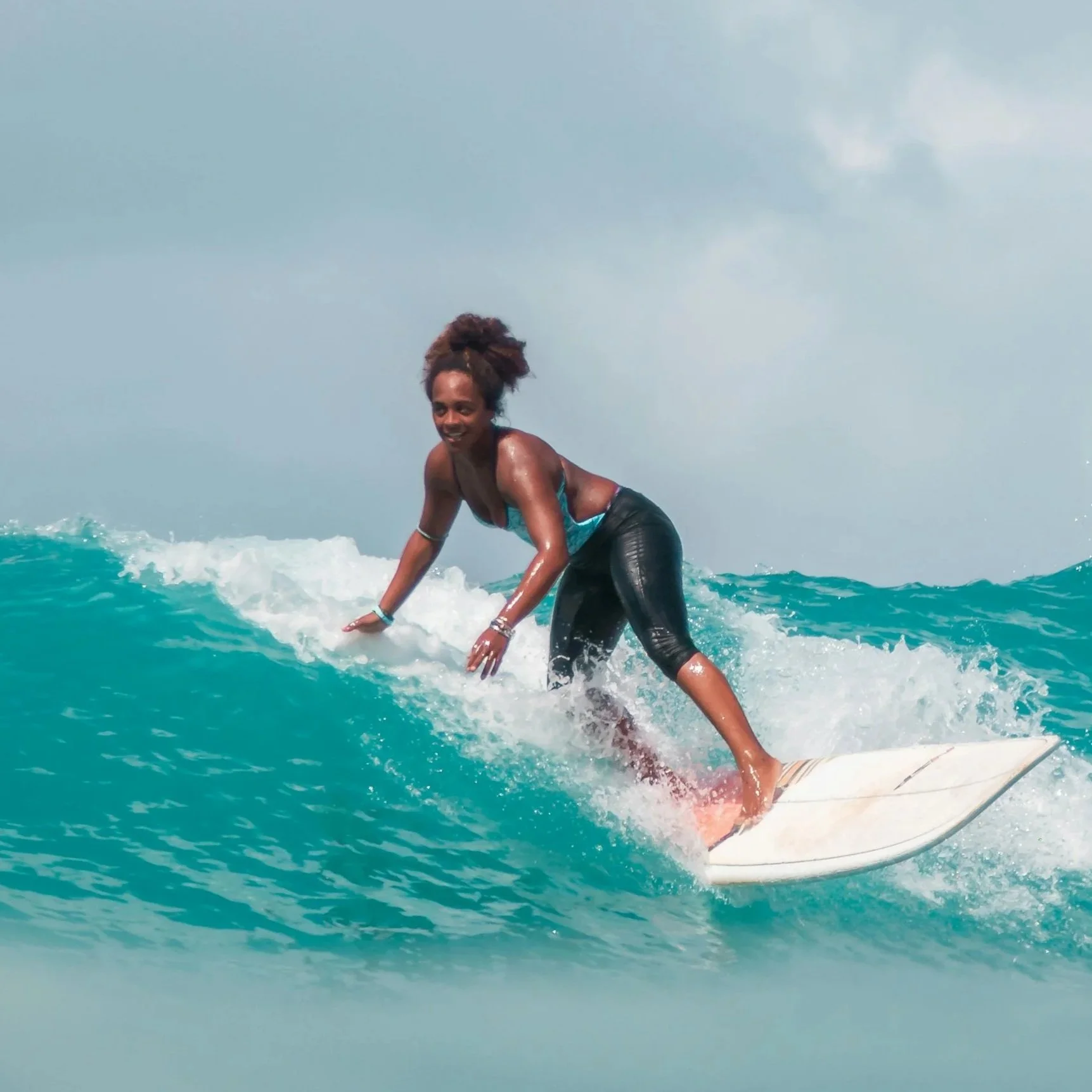 Woman surfing on a turquoise wave.