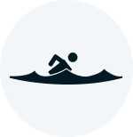 Silhouette of a person swimming in water, viewed from the side.