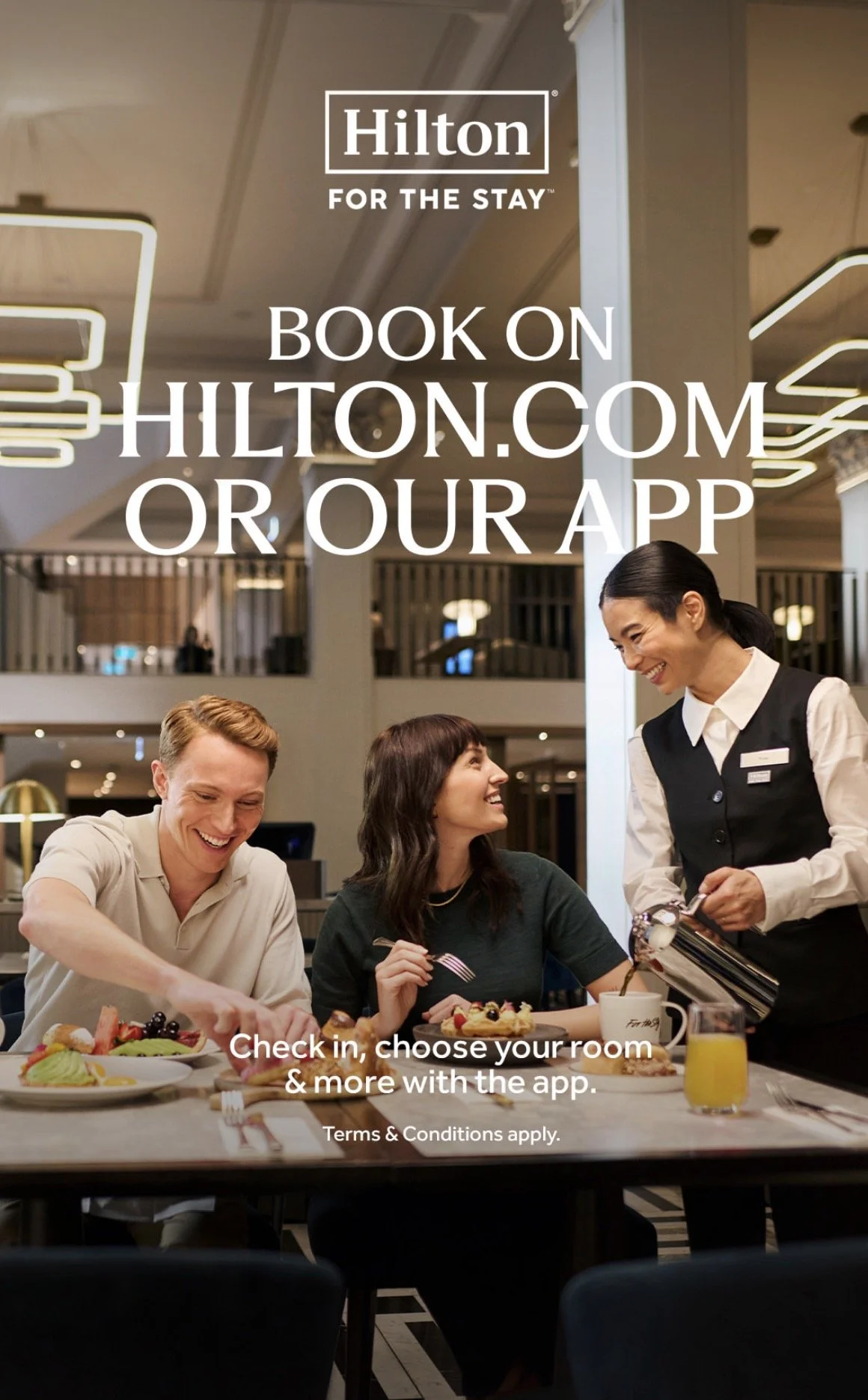 A promotional image for Hilton hotel featuring a smiling hotel staff member serving breakfast to two guests, with text encouraging booking through Hilton.com or their app.