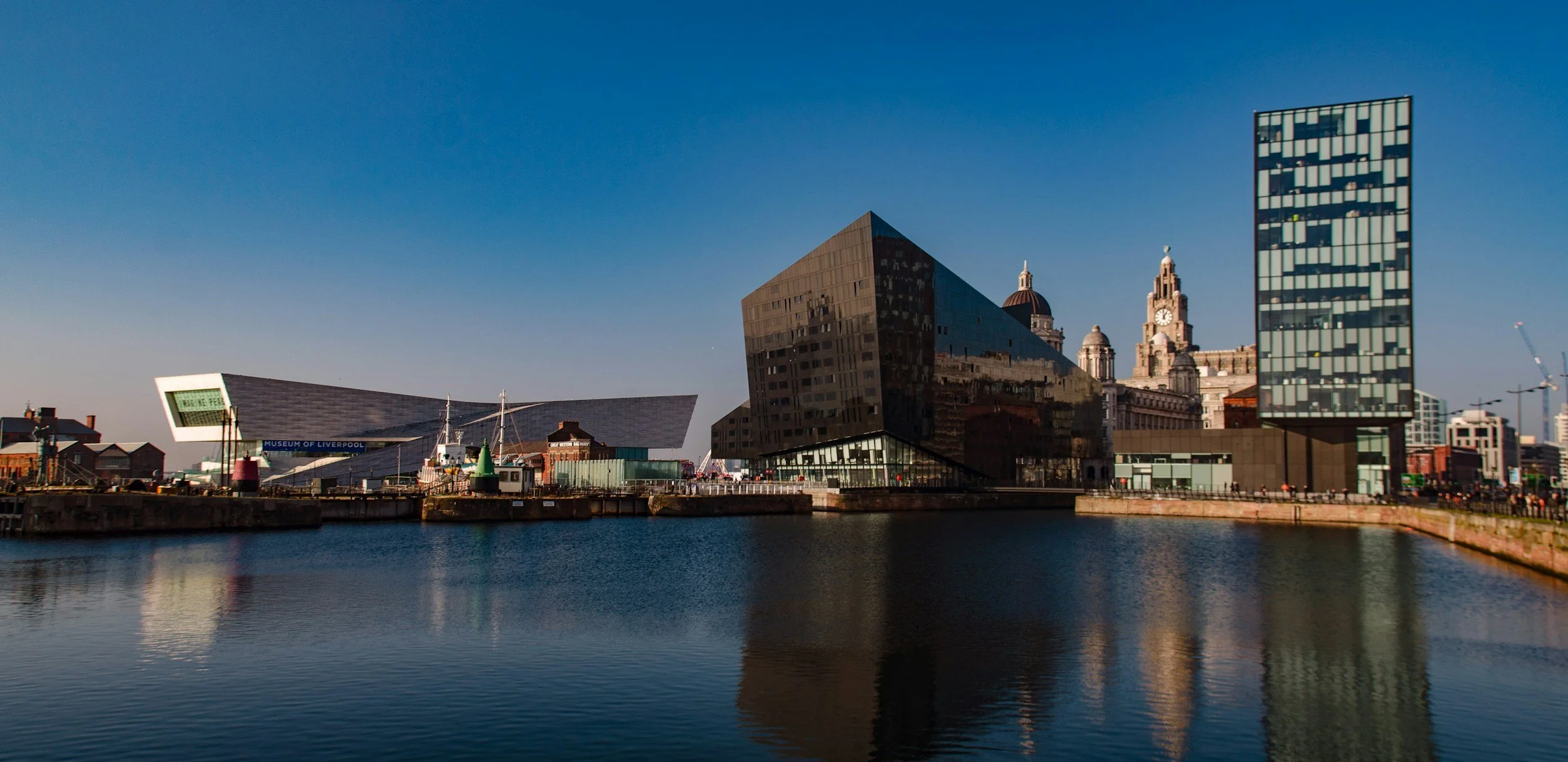 Photo of Liverpool waterfront, water, buildings and blue sky.