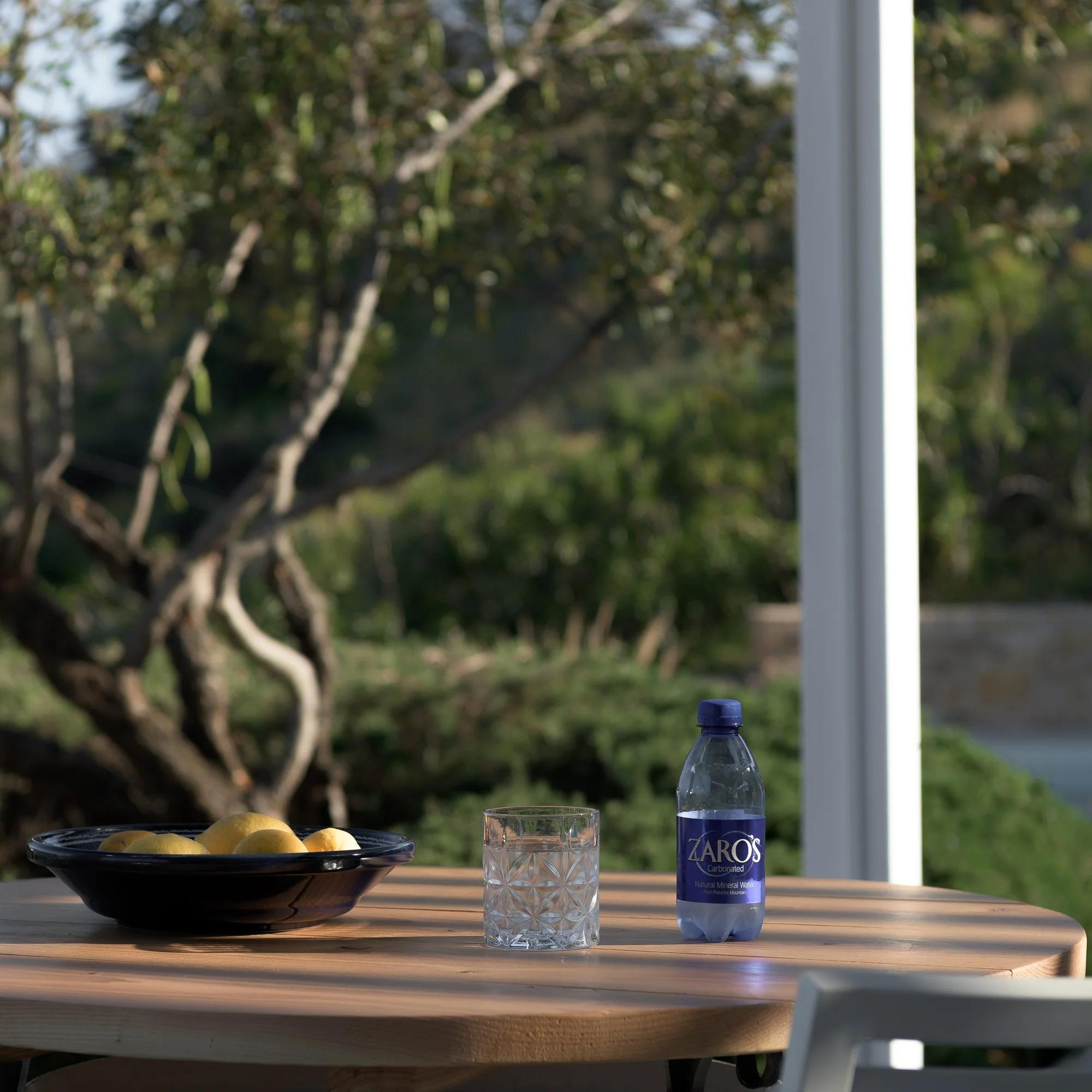 Outdoor breakfast table surrounded by olive trees and Mediterranean greenery in South Crete.