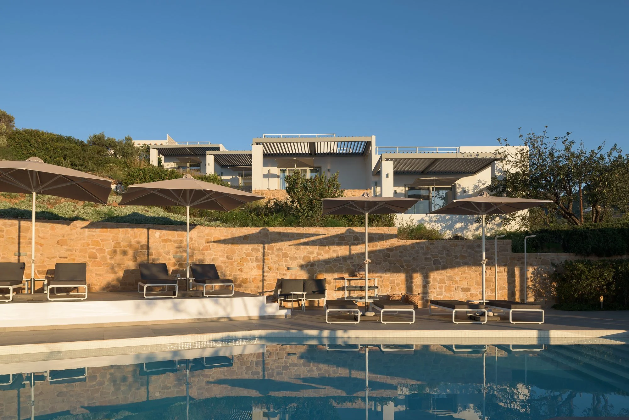 Large communal swimming pool with modern suites on the hills above Agia Galini.