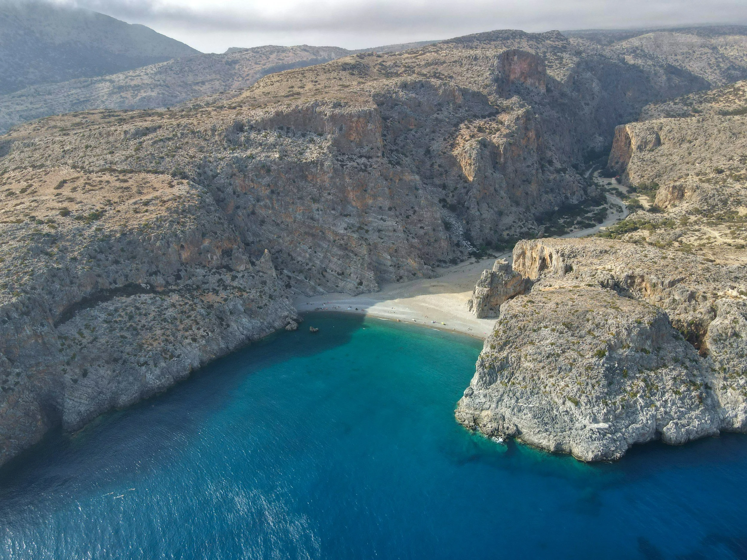 Aerial view of Agiofarago Bay in South Crete with turquoise water, steep rocky cliffs and the remote coastal landscape of the Libyan Sea