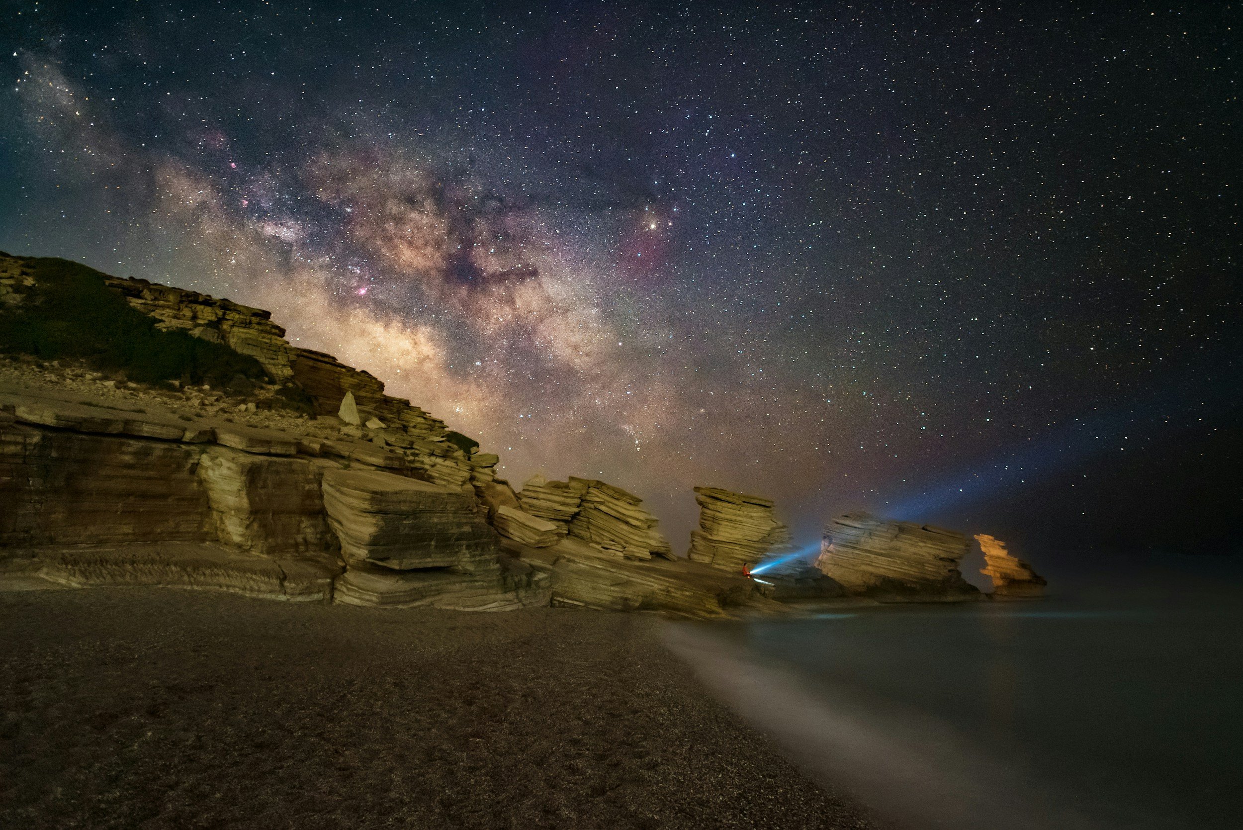 Rock formations and beach at Triopetra in South Crete under the Milky Way, showcasing the wild coastline and dark night skies of the Libyan Sea region
