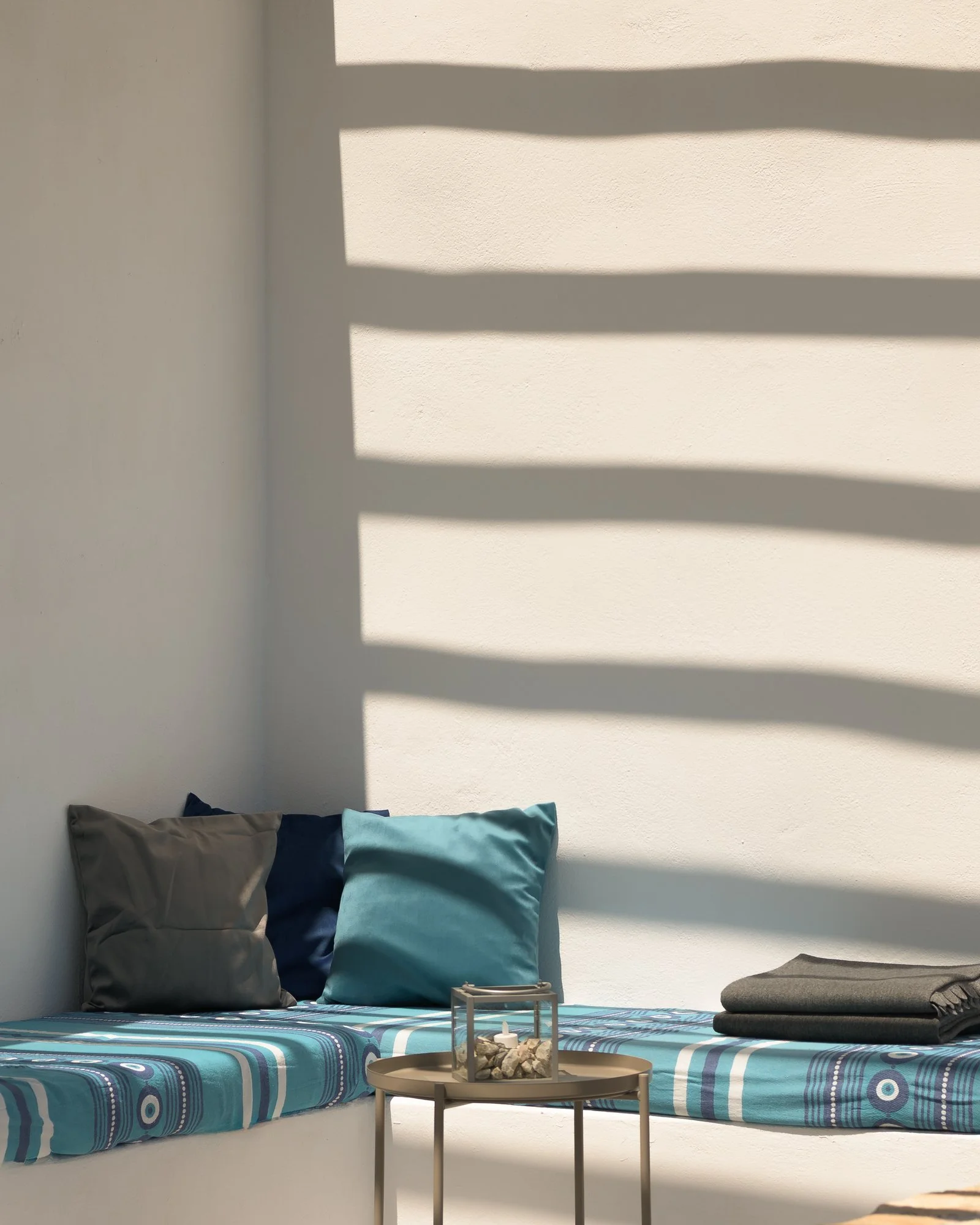 Cozy outdoor lounge corner with contemporary built-in seating and natural light.