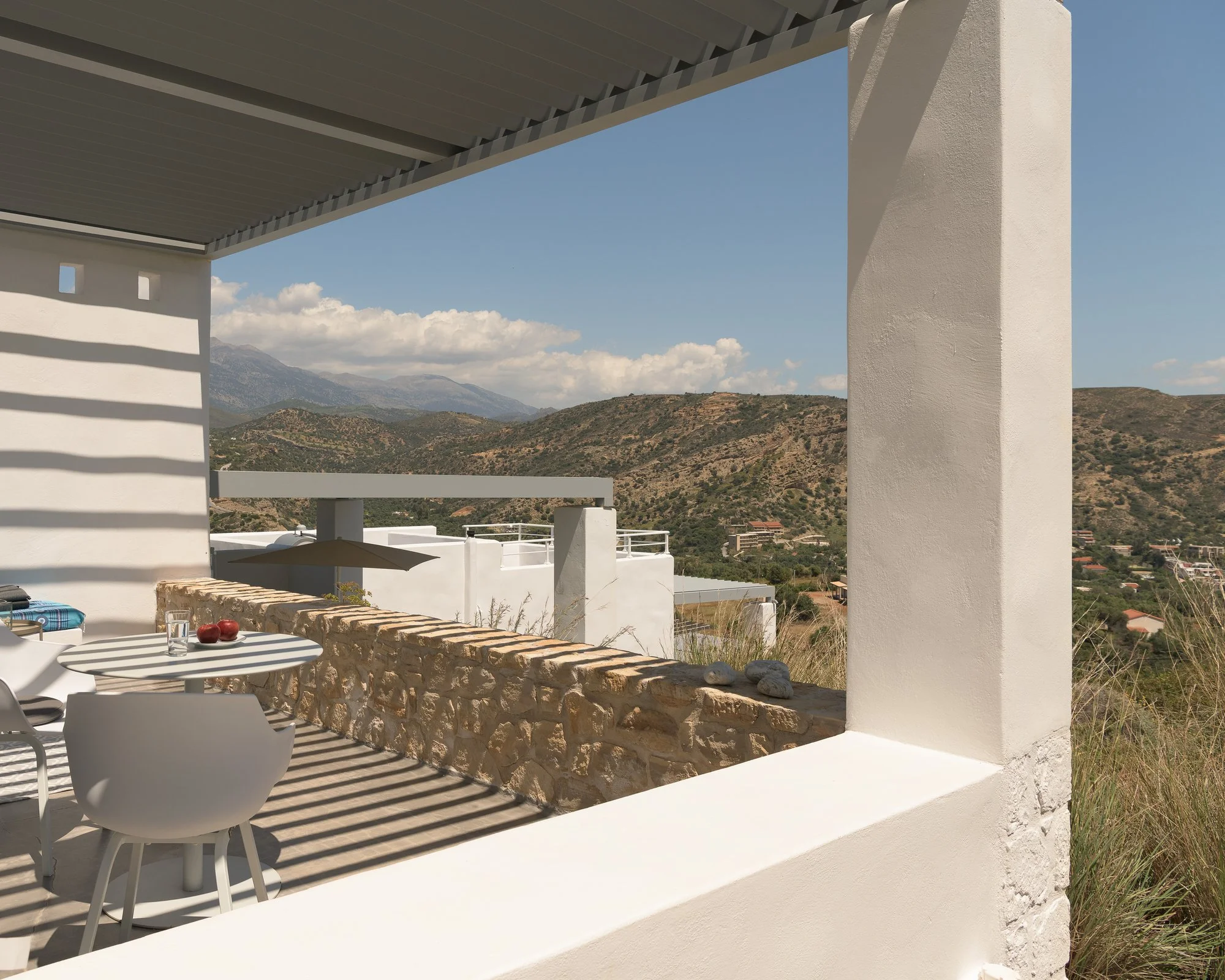 Pergola-covered outdoor dining area overlooking the coastline of South Crete.