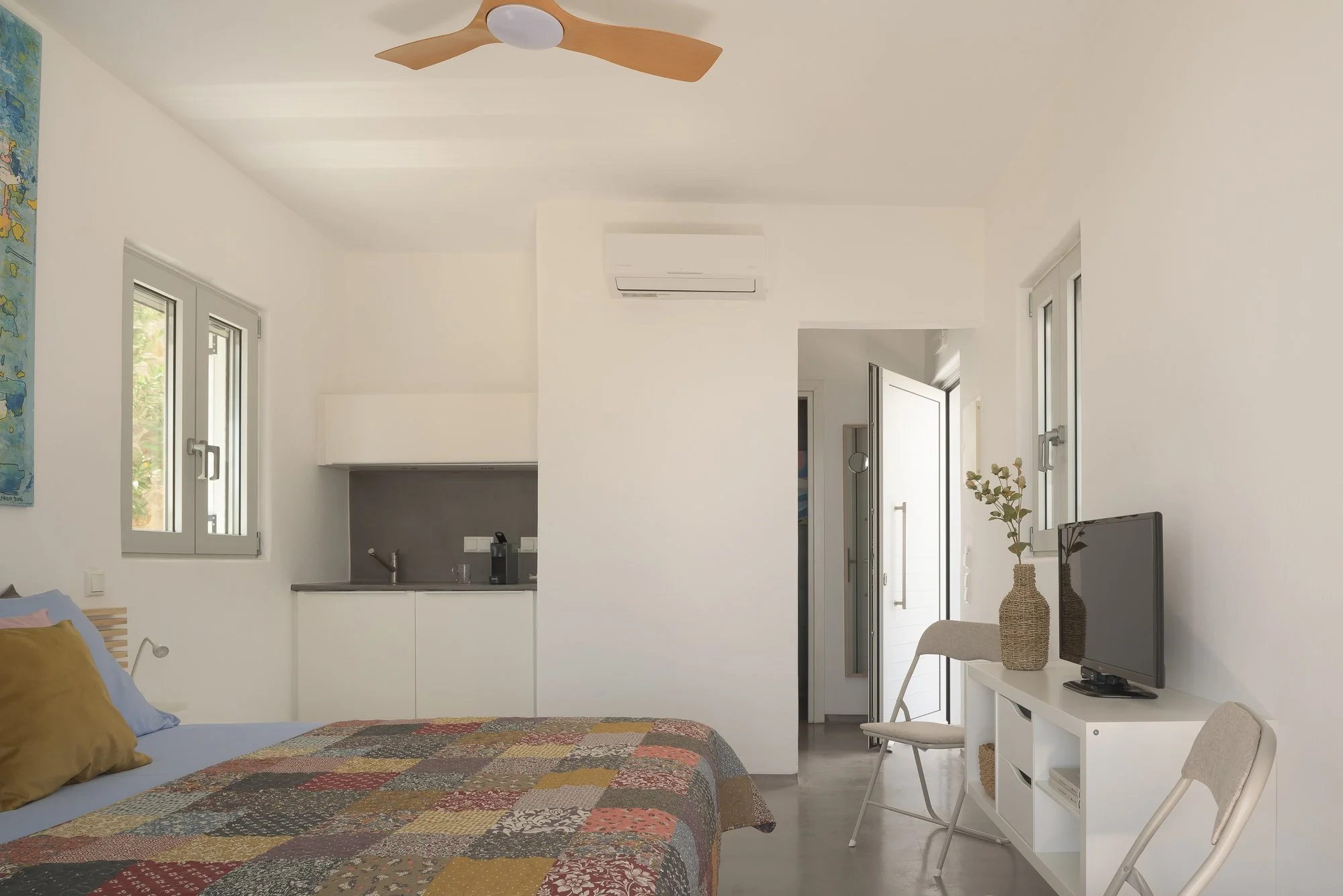 Modern minimalist suite interior with contemporary furnishings and natural Mediterranean light.