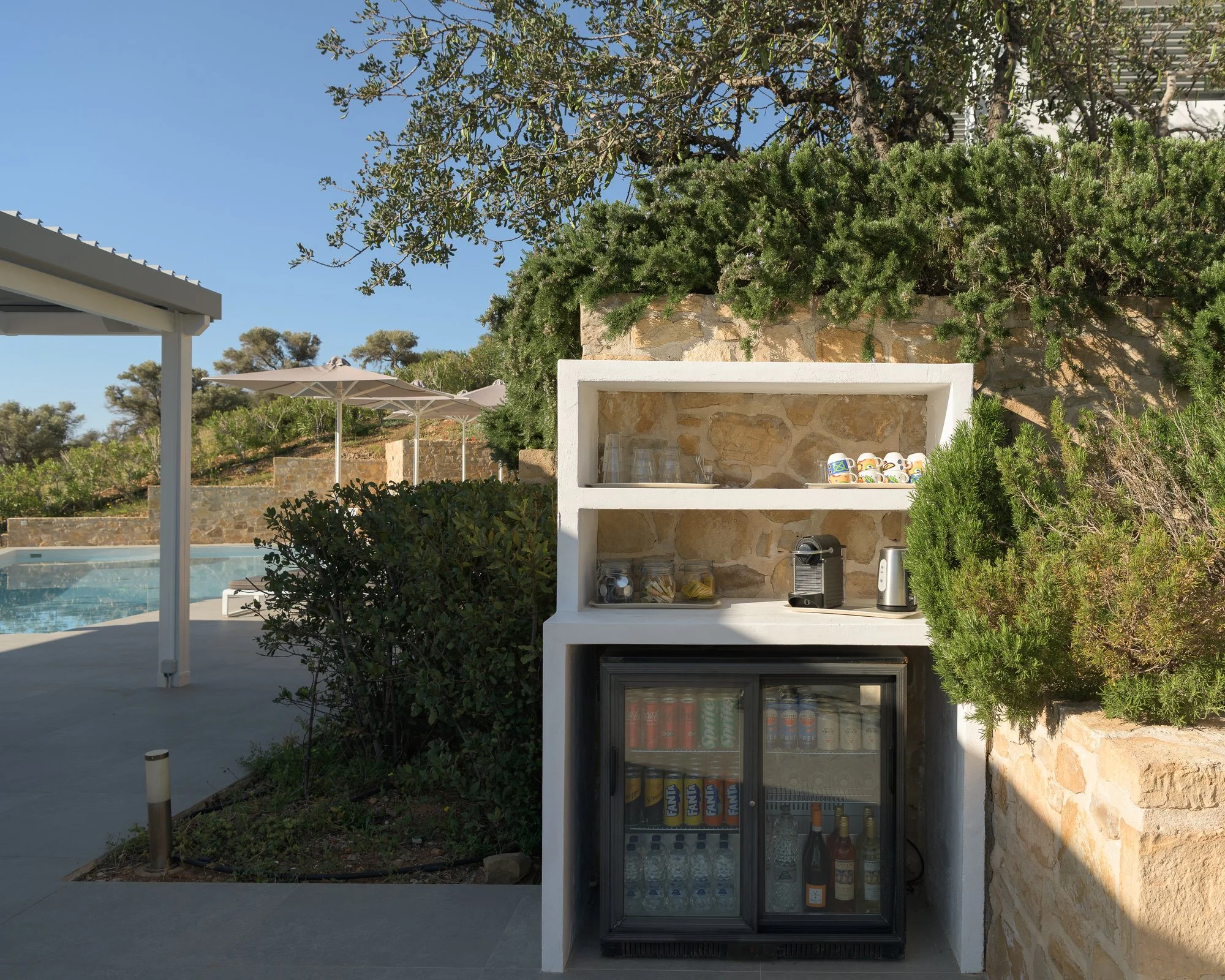 Outdoor refreshment corner, called honesty bar, surrounded by Mediterranean greenery at an adults-only retreat in South Crete.