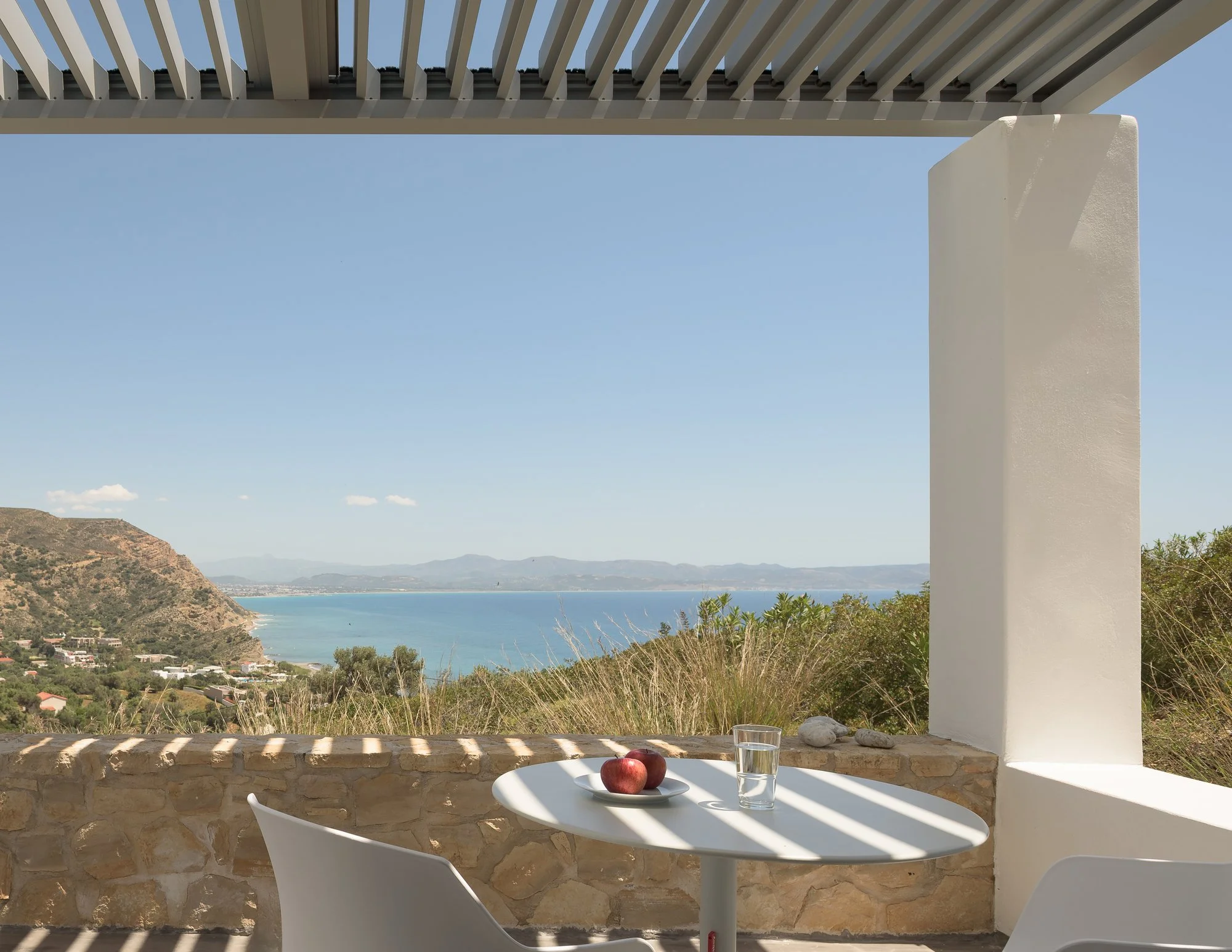 Pergola-covered outdoor dining area with panoramic Libyan Sea and mountain views.