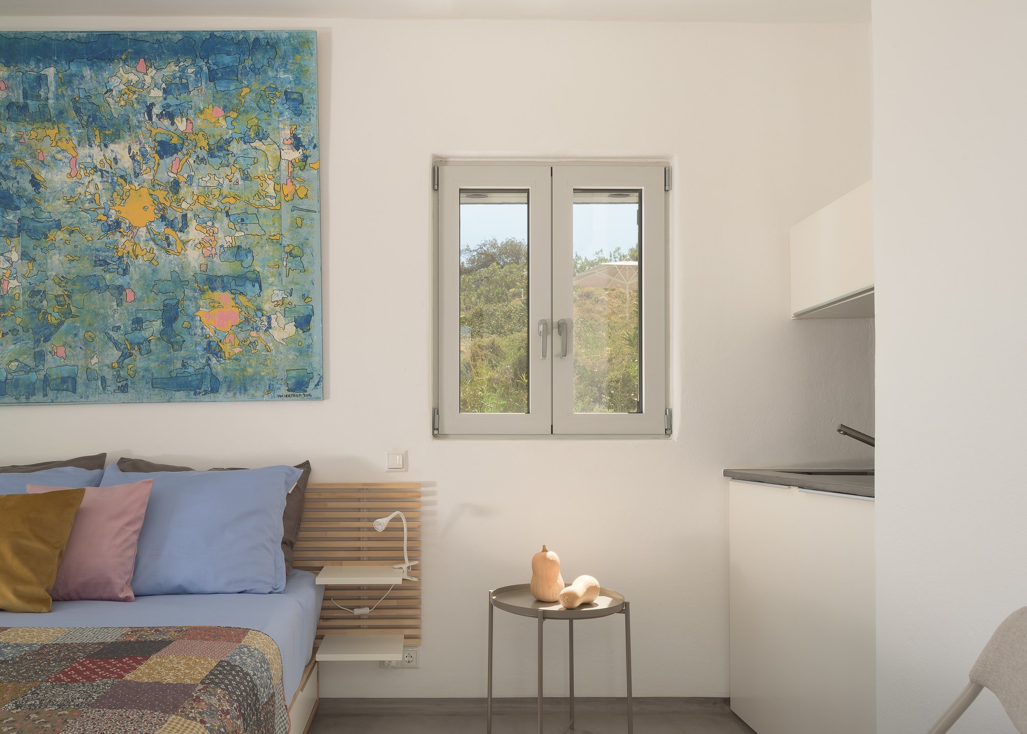 Contemporary bedroom with abstract artwork and boutique coastal aesthetics.