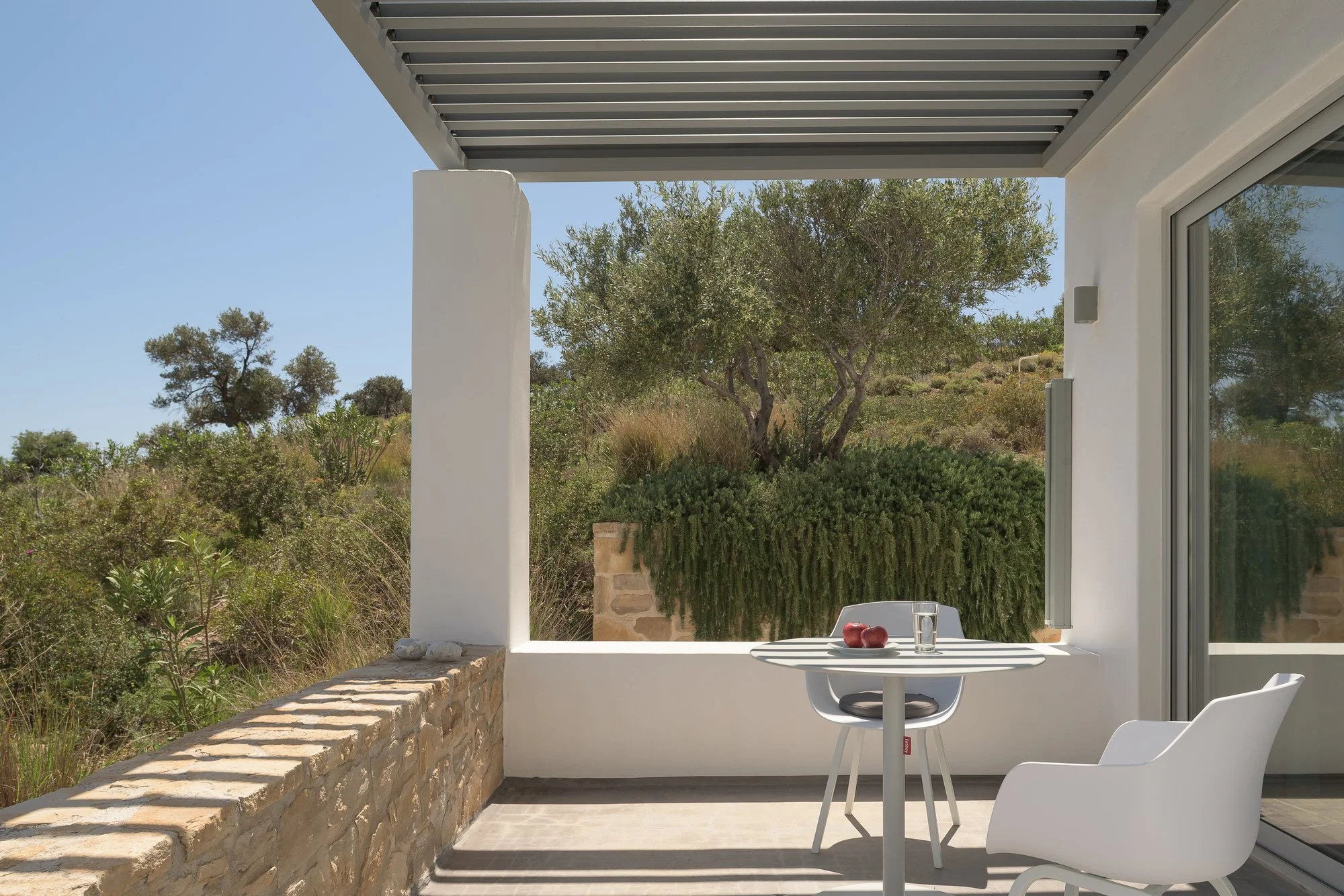 Private shaded terrace with minimalist outdoor seating at Galini Breeze adults-only suites.