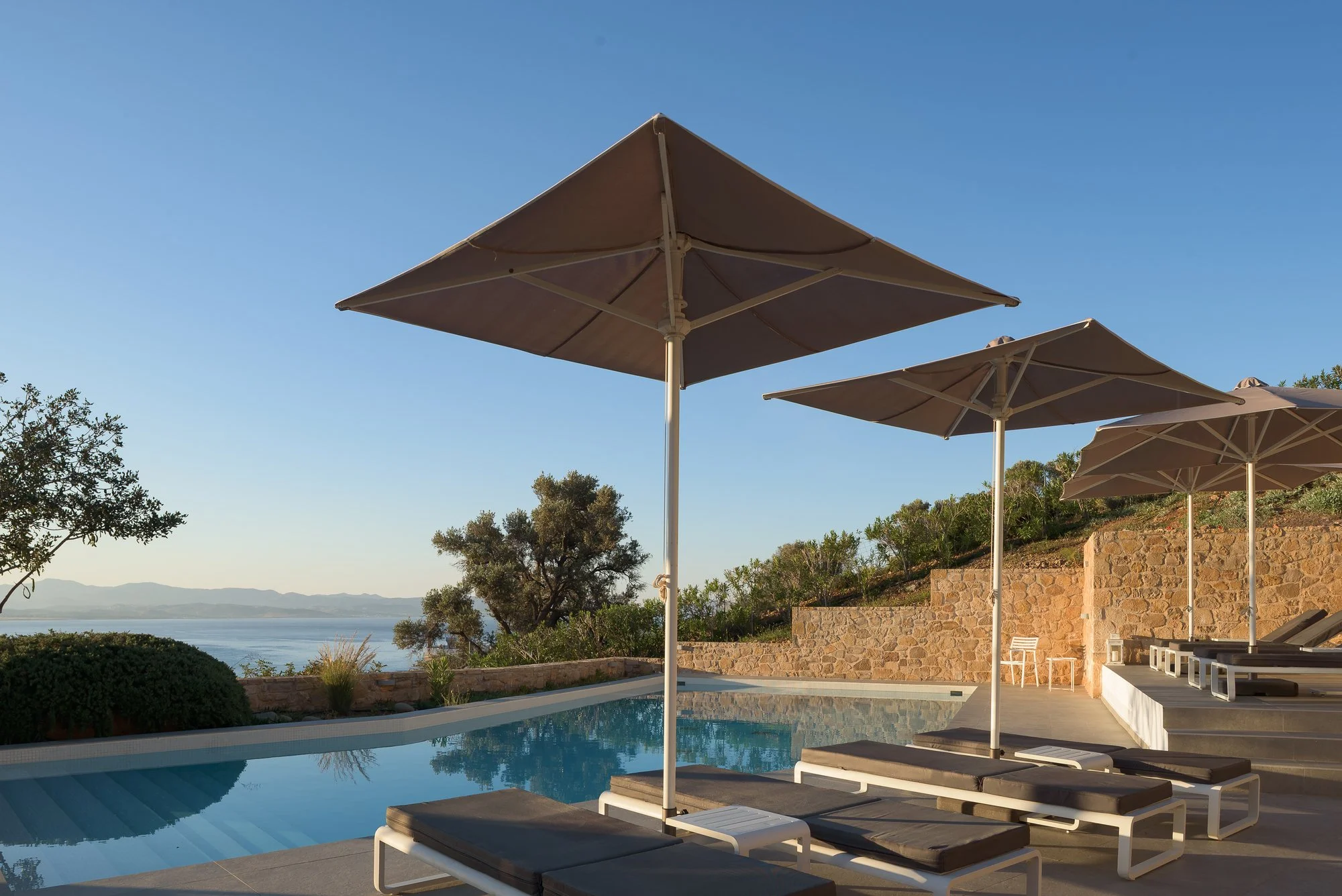 Minimalist infinity pool with mountain scenery in South Crete.