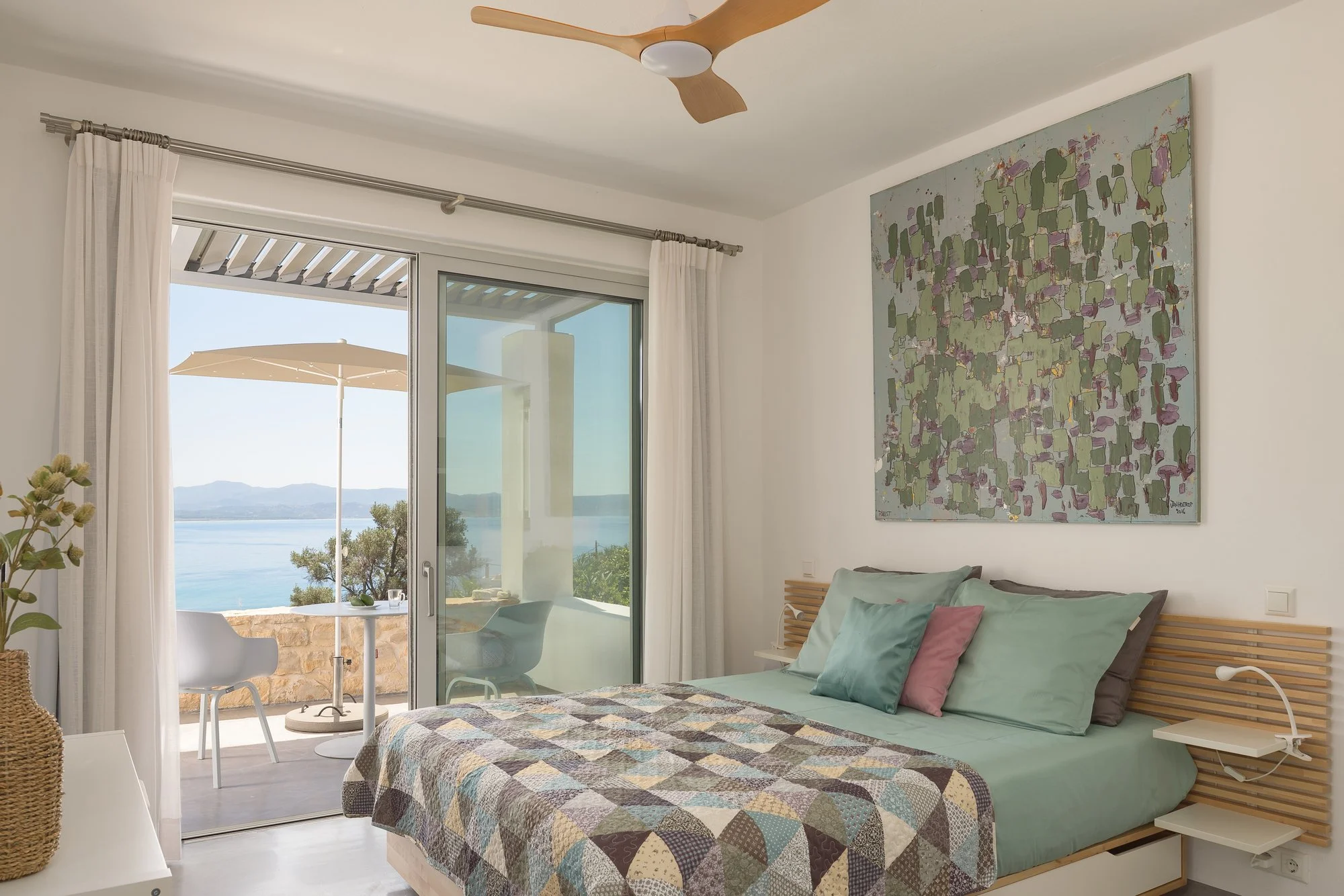 Luxury bedroom with panoramic terrace access and contemporary Mediterranean décor.
