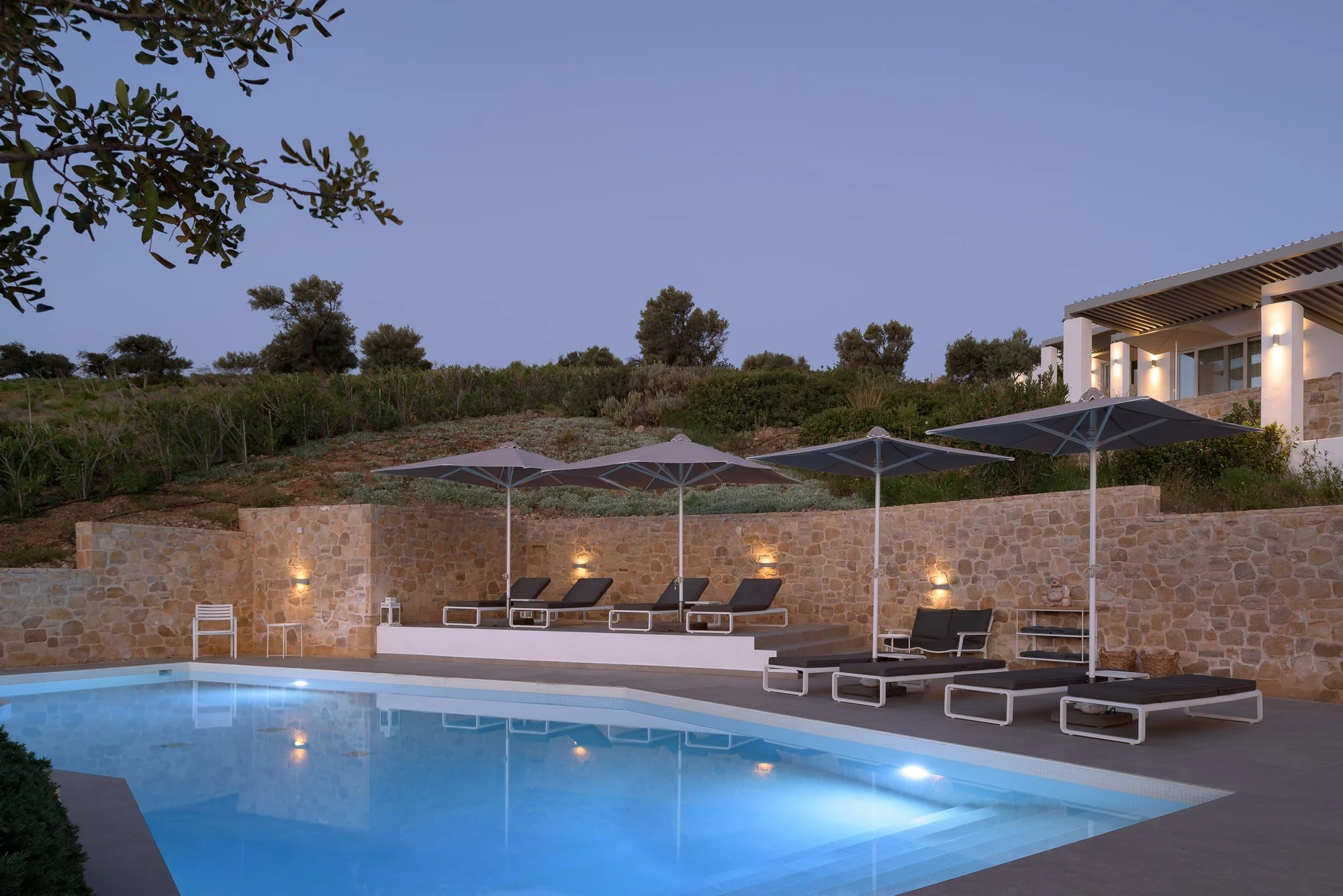 Outdoor heated swimming pool with ambient evening lighting at Galini Breeze boutique retreat.