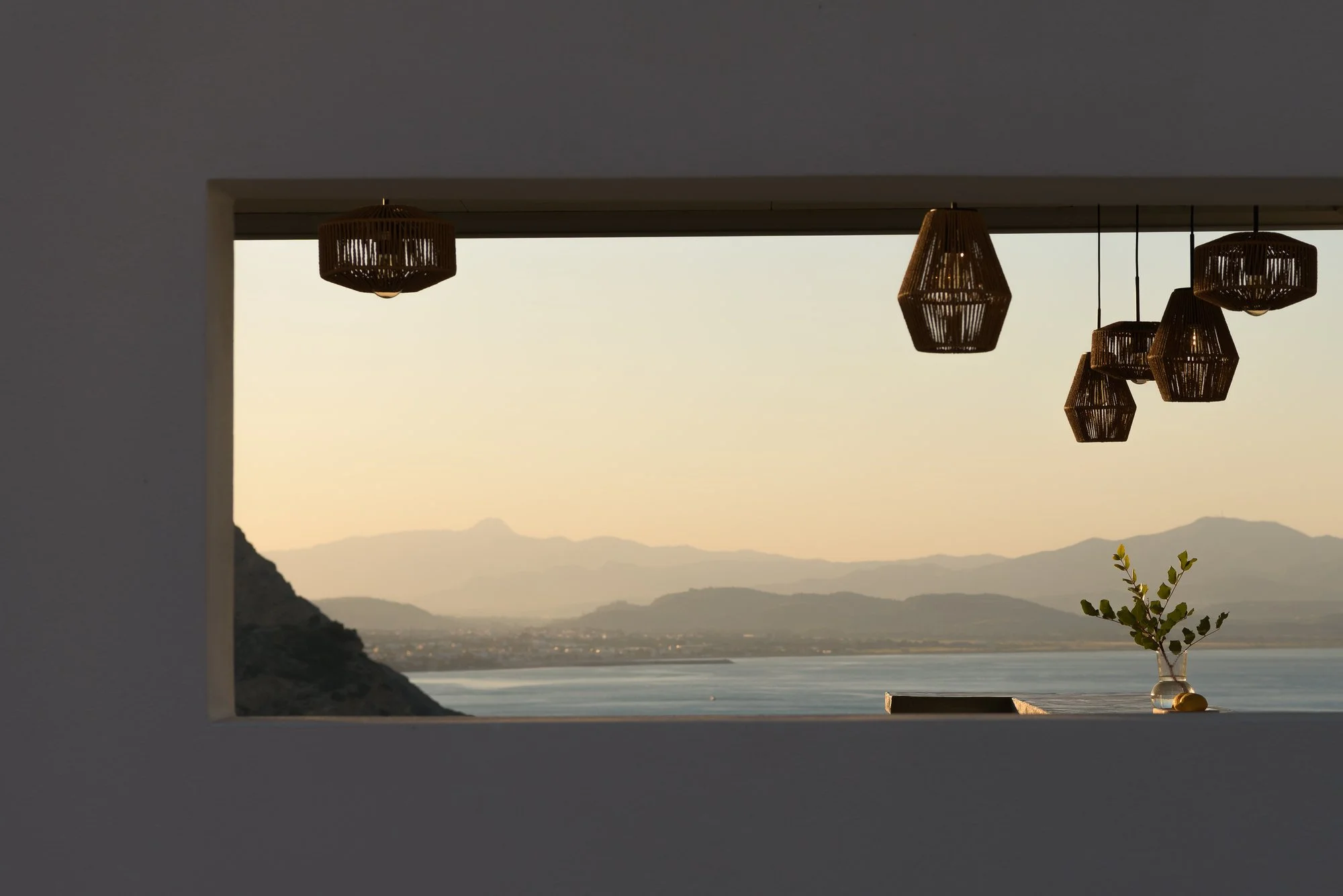 Framed sunset view over the Libyan Sea through a minimalist studio window in Agia Galini.