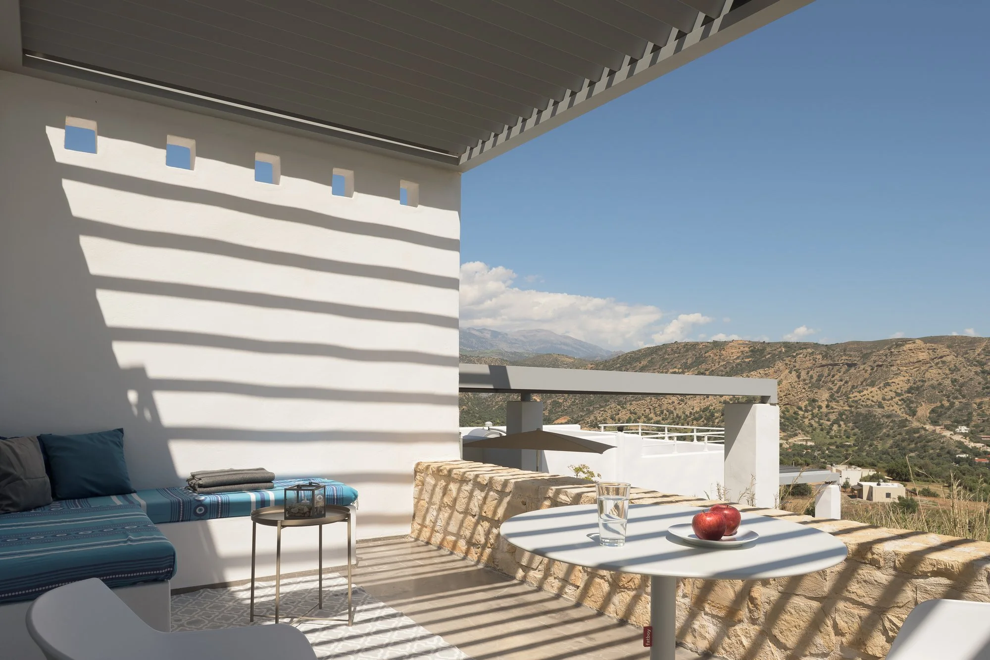 Luxury balcony with panoramic Libyan Sea views and outdoor breakfast setting.