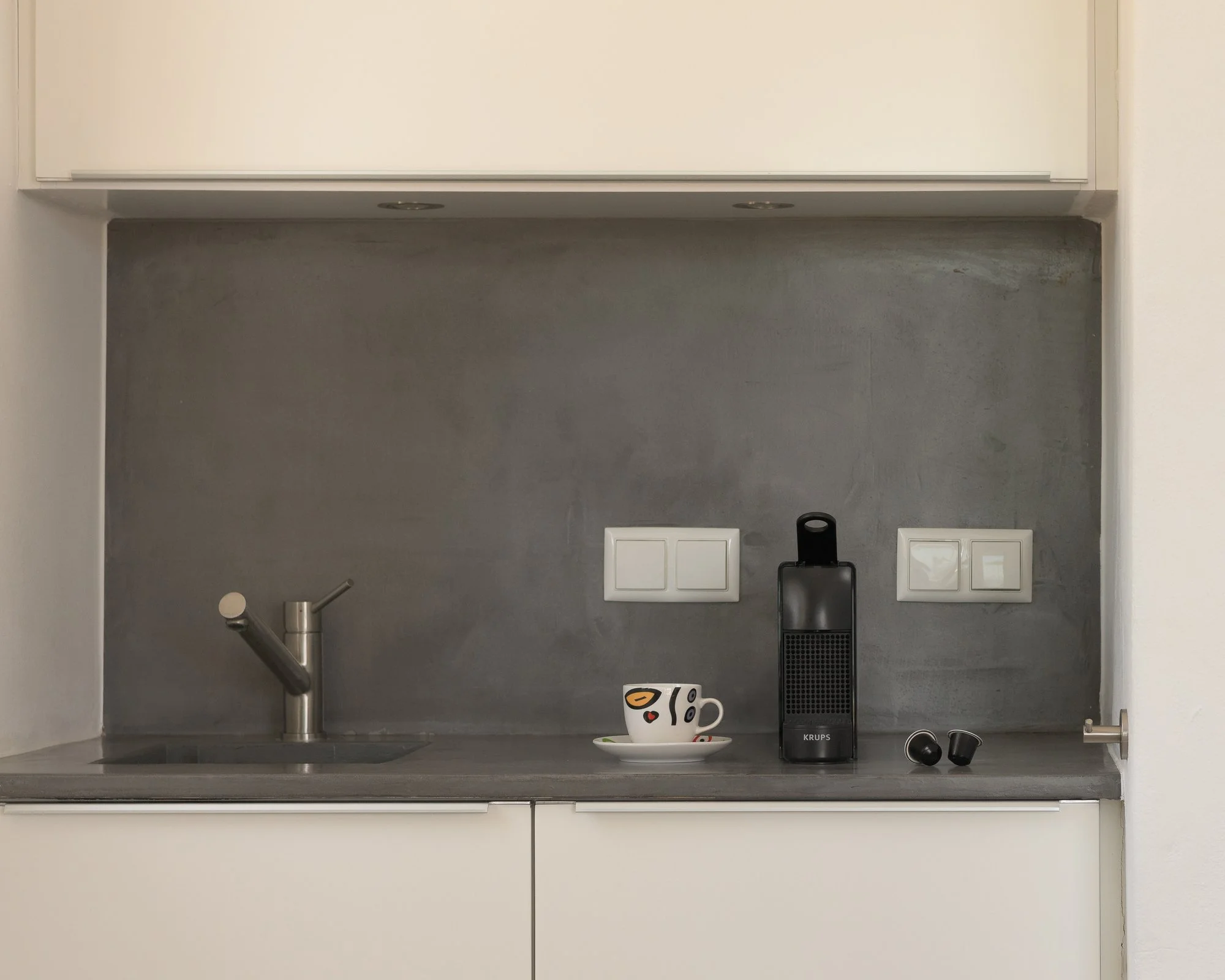 Minimalist kitchenette with contemporary finishes and premium in-room amenities.
