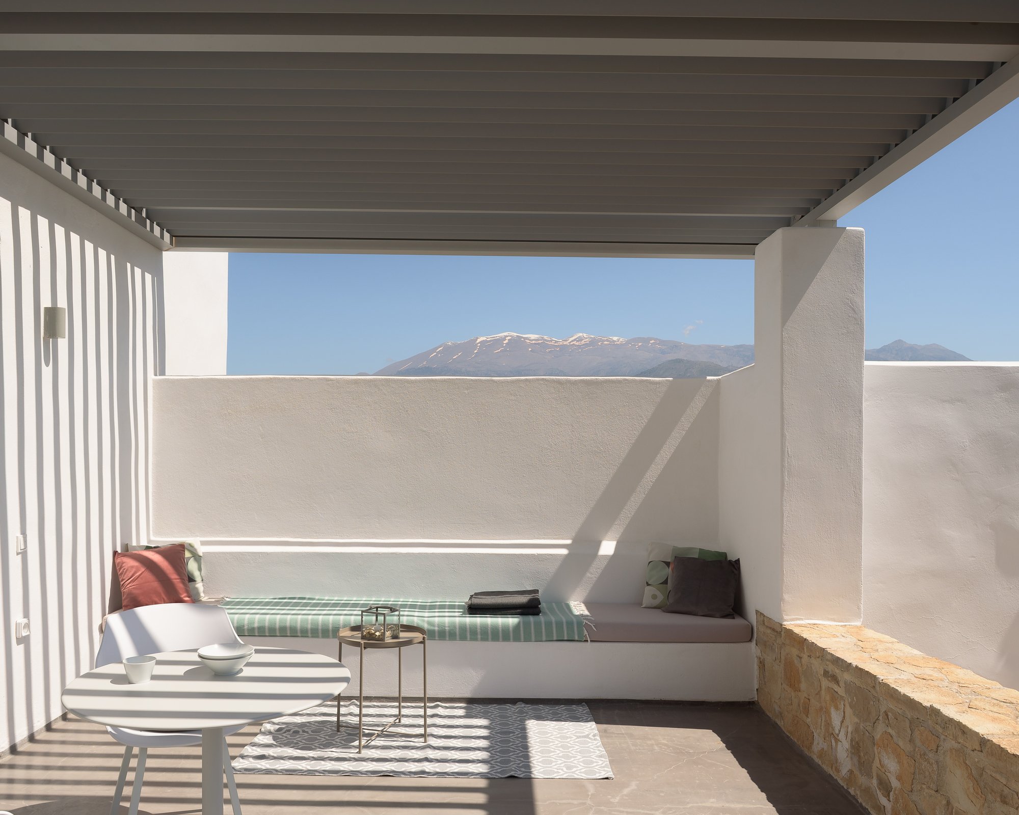 Private shaded balcony with modern outdoor lounge furniture in South Crete.