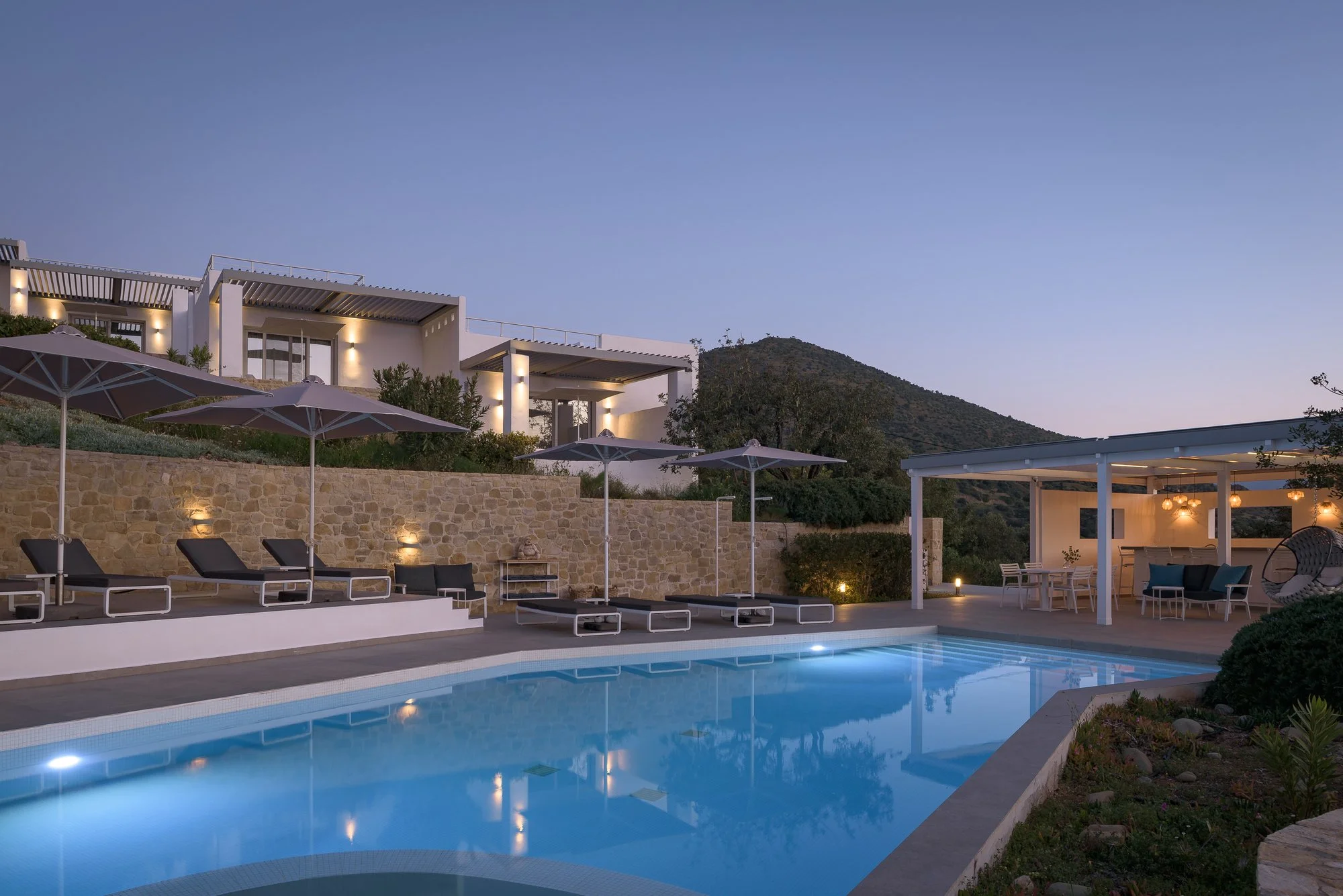 Luxury infinity-style pool illuminated at blue hour in South Crete.