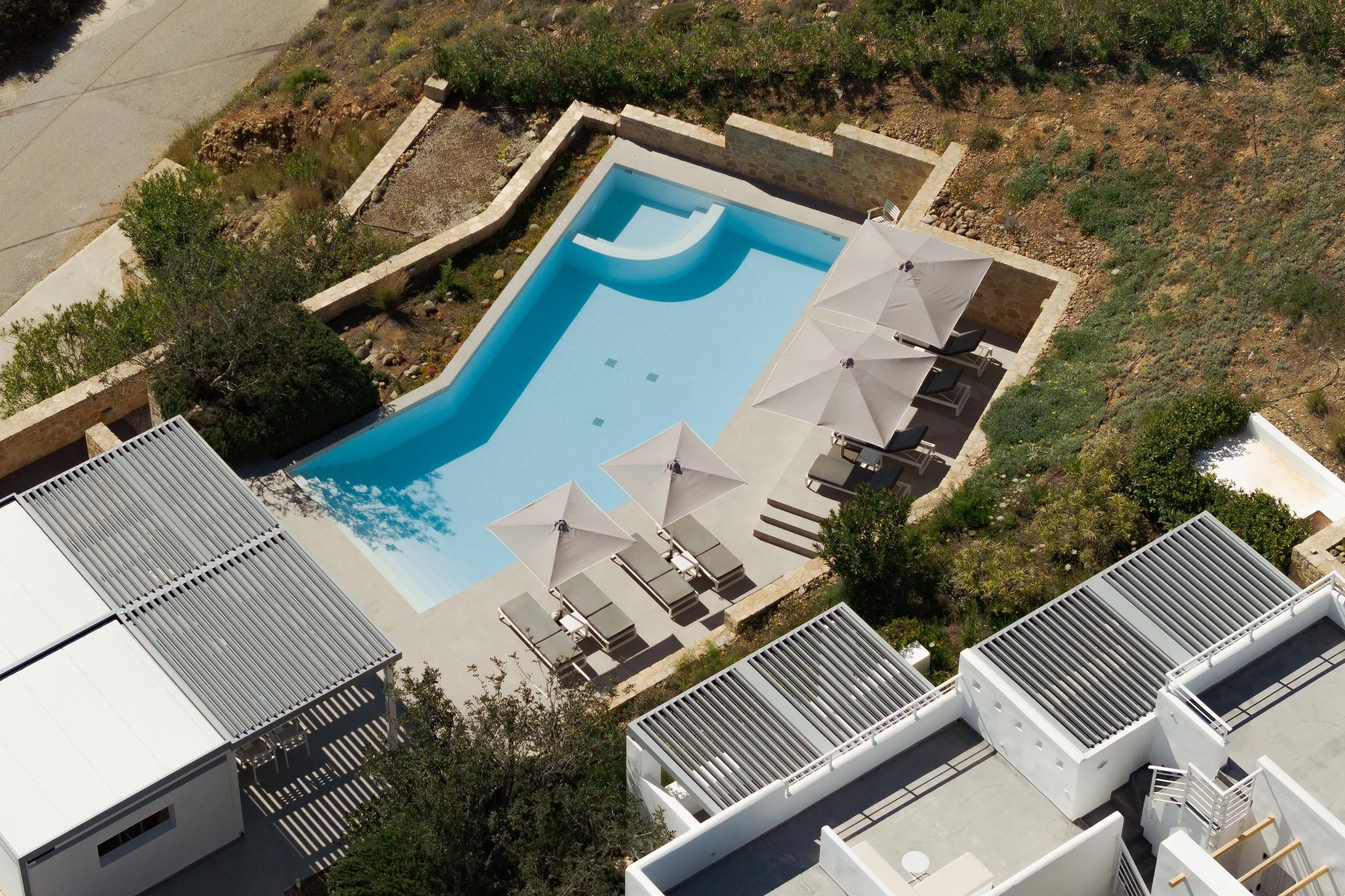 Drone view of boutique pool terrace and contemporary architecture near Agia Galini.