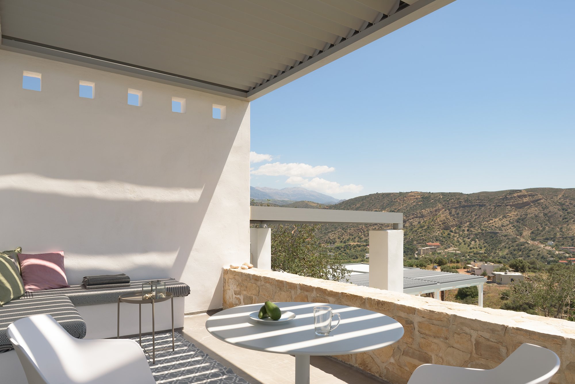 Sea-view outdoor dining terrace with minimalist Mediterranean design.