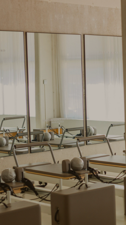 Salon or fitness studio with adjustable beds and mirrors on the wall