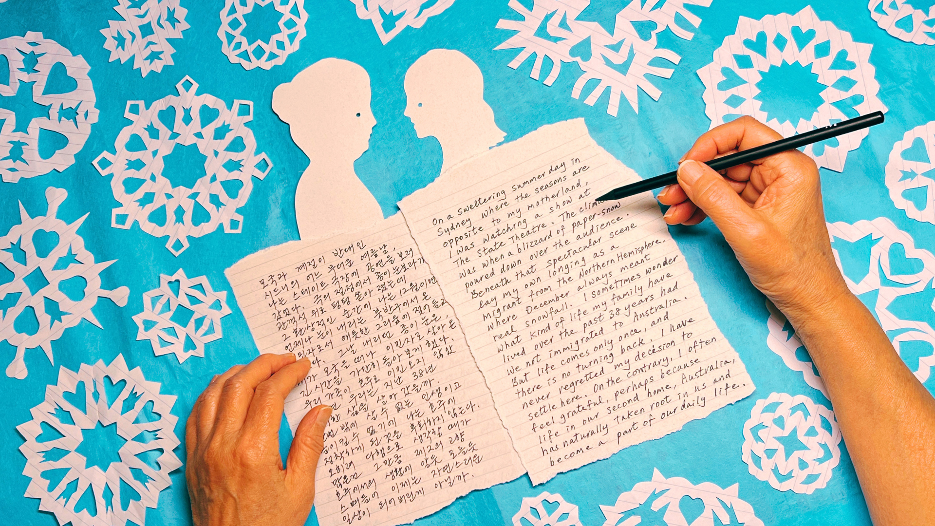 Paper-cut artwork by Kay Yasugi for Snow on a Summer's Day — two silhouettes among paper snowflakes, with Youngkyu Kwon's handwritten bilingual essay.